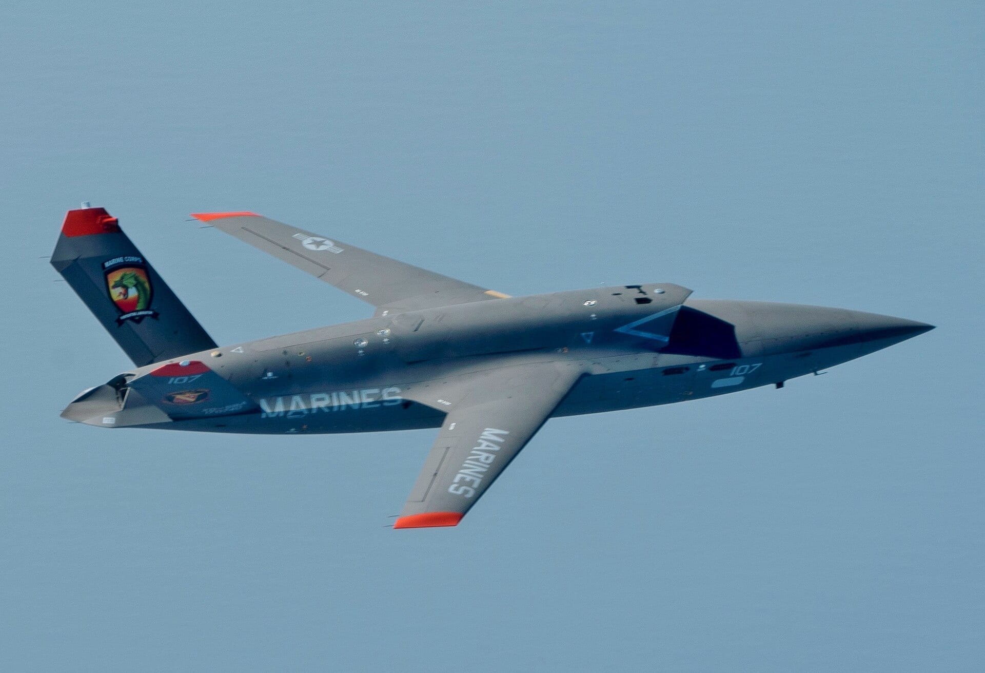 A U.S. Marine Corps XQ-58A Valkyrie in flight with MARINES marking on its wing during a test flight