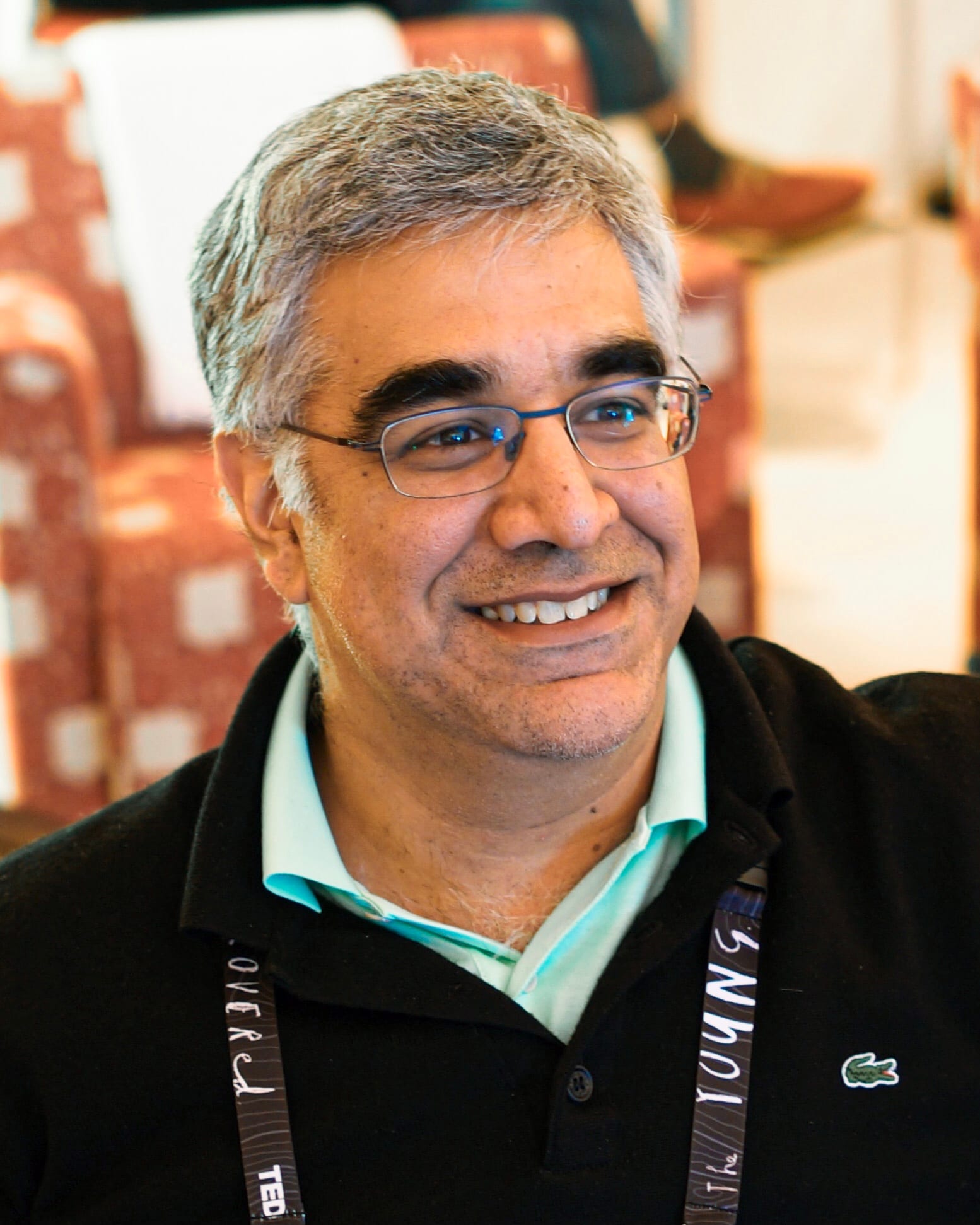 Aneel Bhusri, cofounder of Workday, smiling in a black jacket and glasses at a conference.