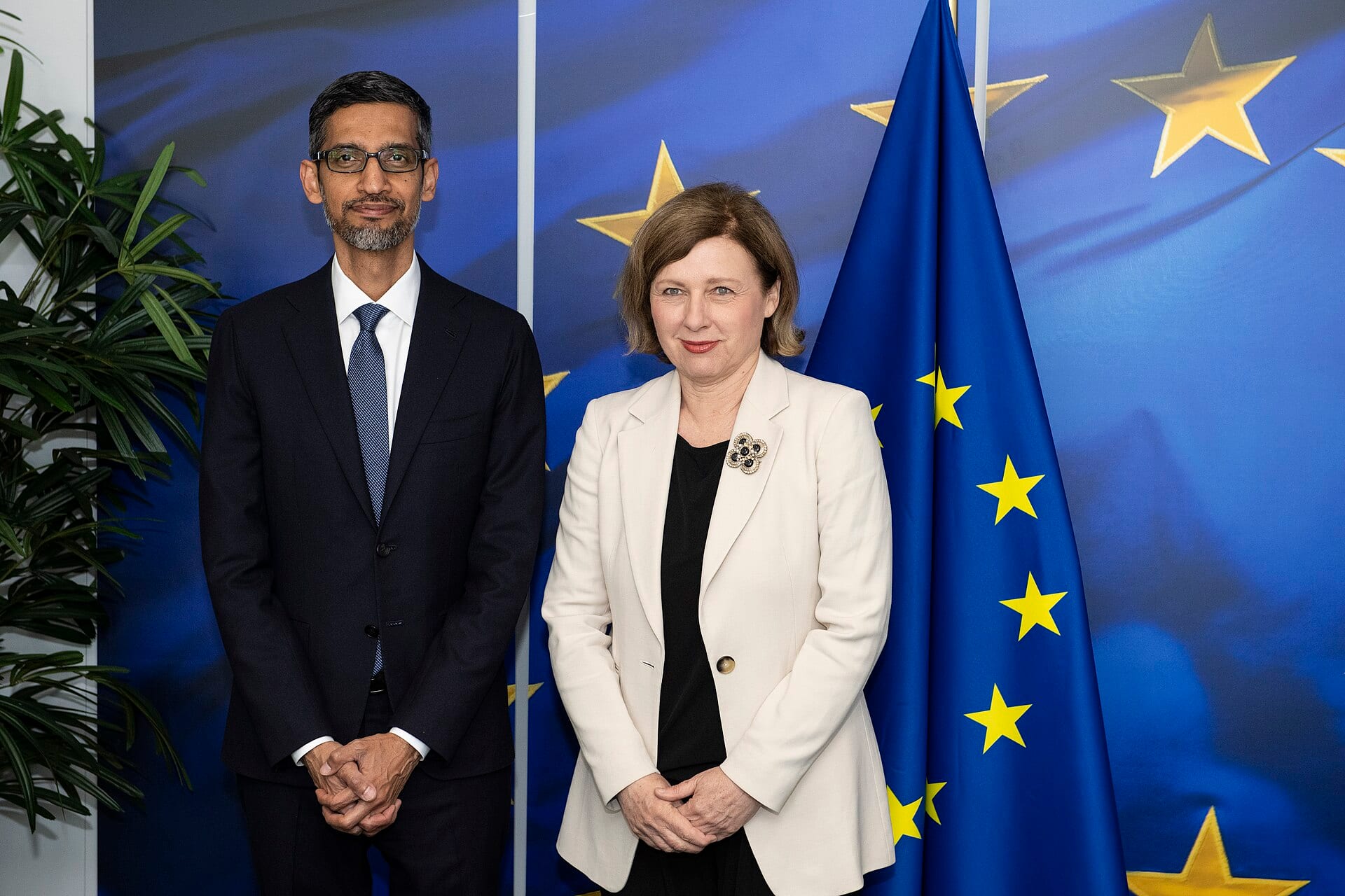 Sundar Pichai and Věra Jourová pose in front of European Union flags in Brussels
