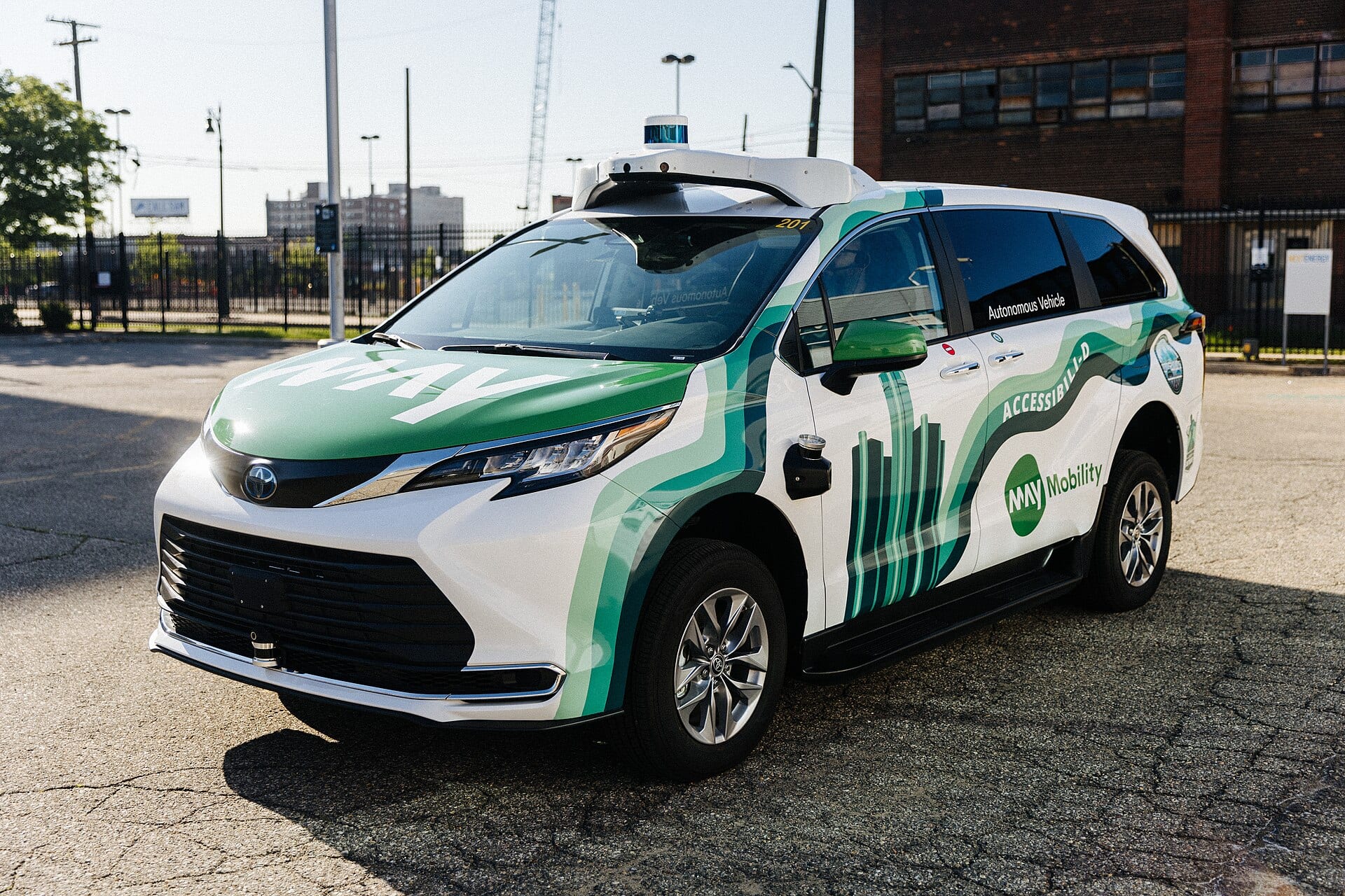May Mobility autonomous Toyota Sienna minivan with roof-mounted lidar sensors on a Detroit street