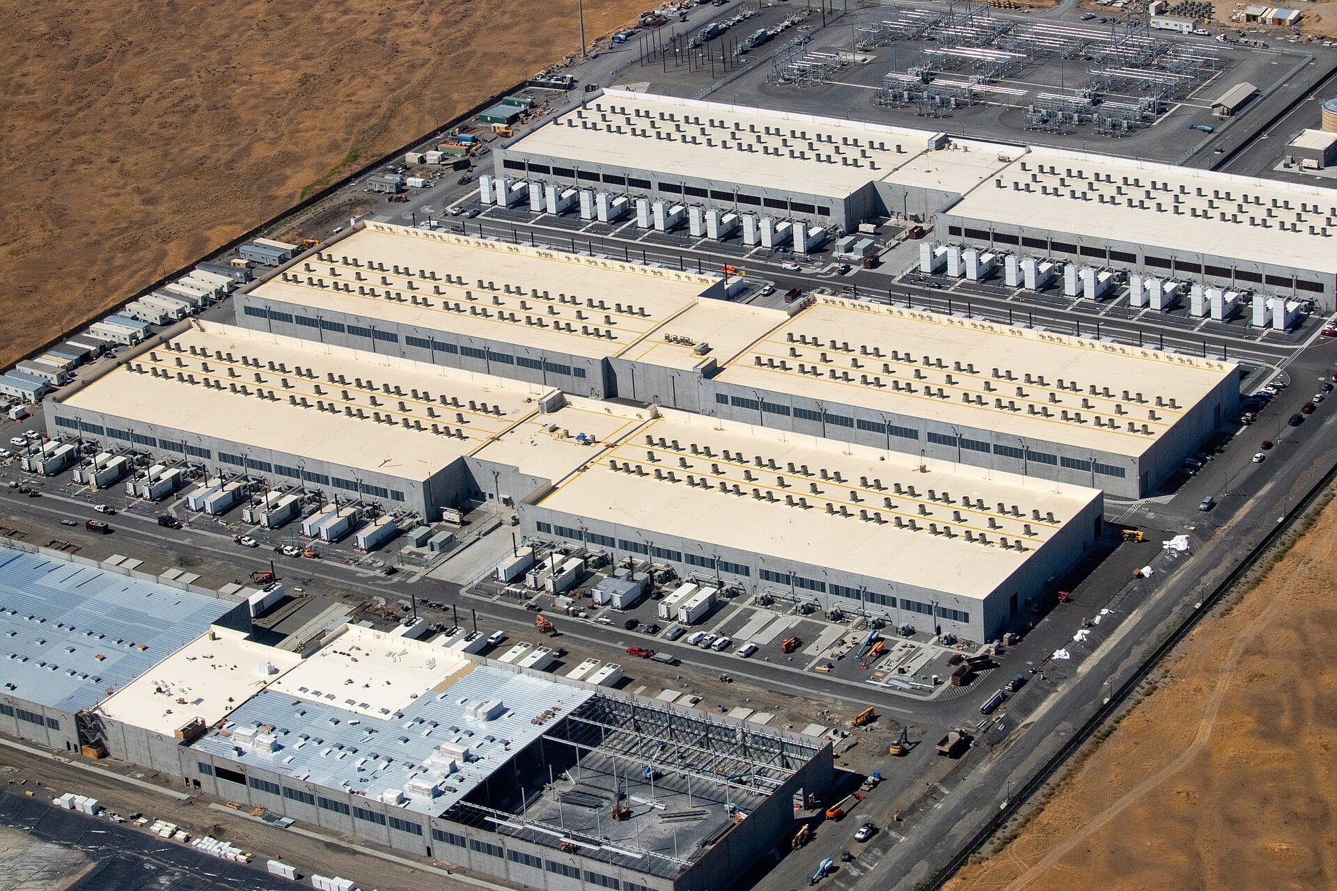Aerial view of an AWS availability zone in Oregon, with large data center buildings and a fourth under construction