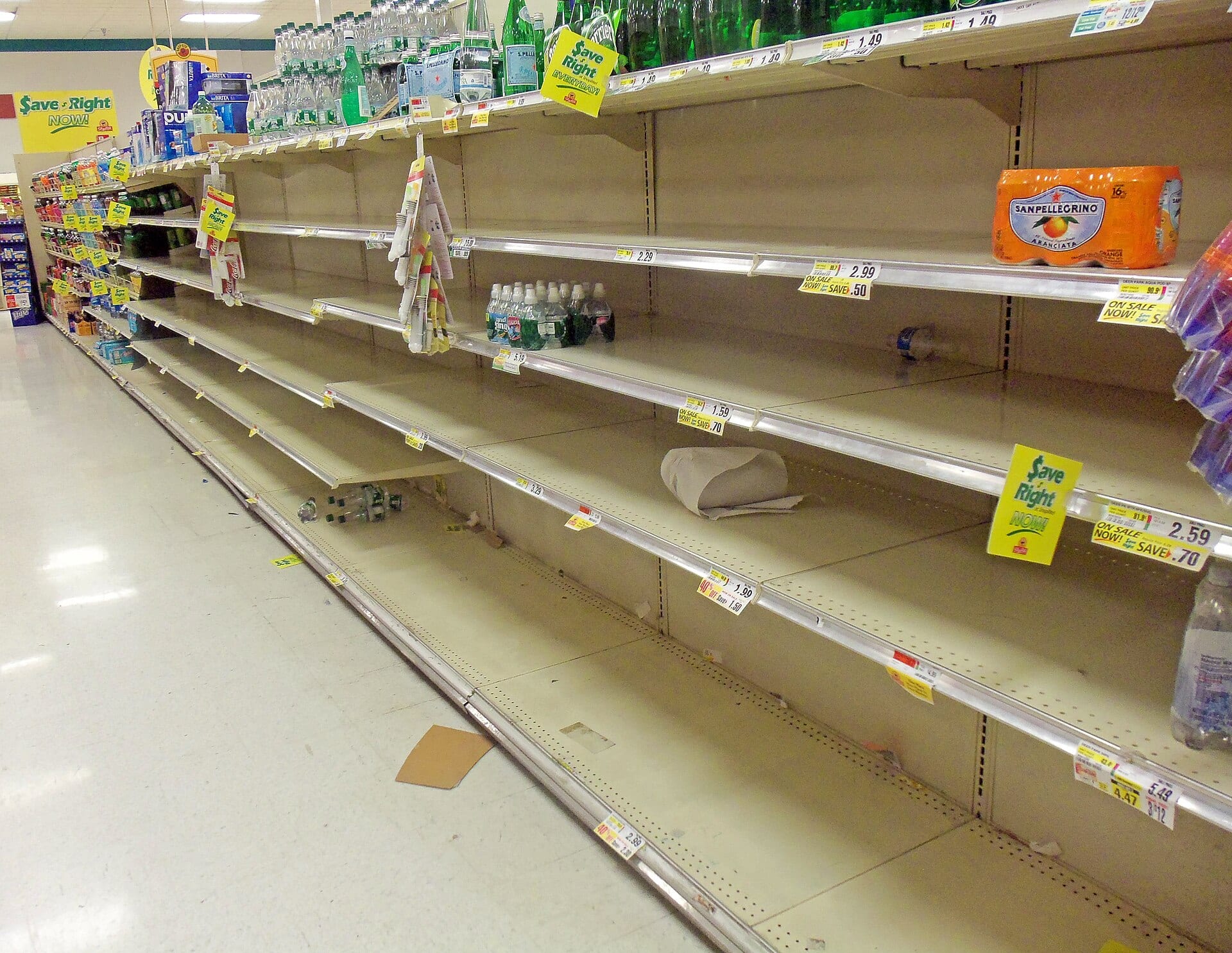 A ShopRite aisle with gaps on the main shelves while product sits on the higher shelf line above them