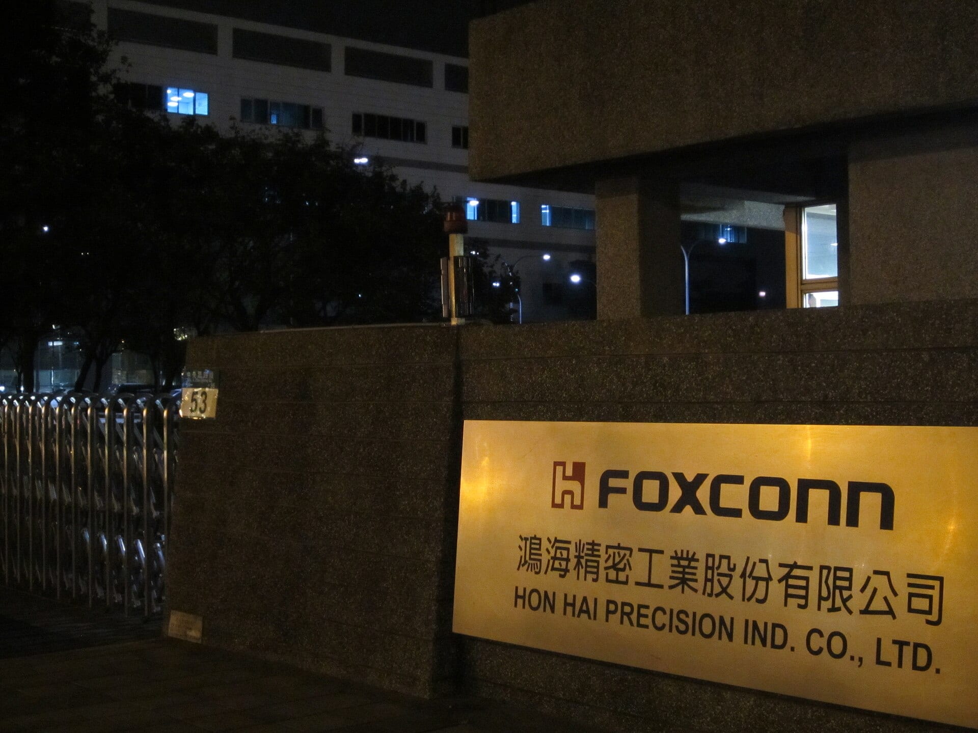 A lit Foxconn sign at the night gate of a Hon Hai Precision plant