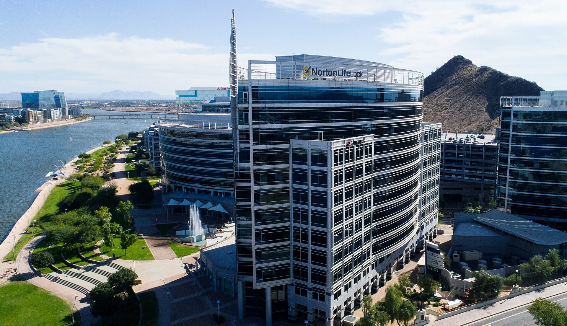 The NortonLifeLock headquarters tower in Tempe, Arizona, rising over a desert lakefront park