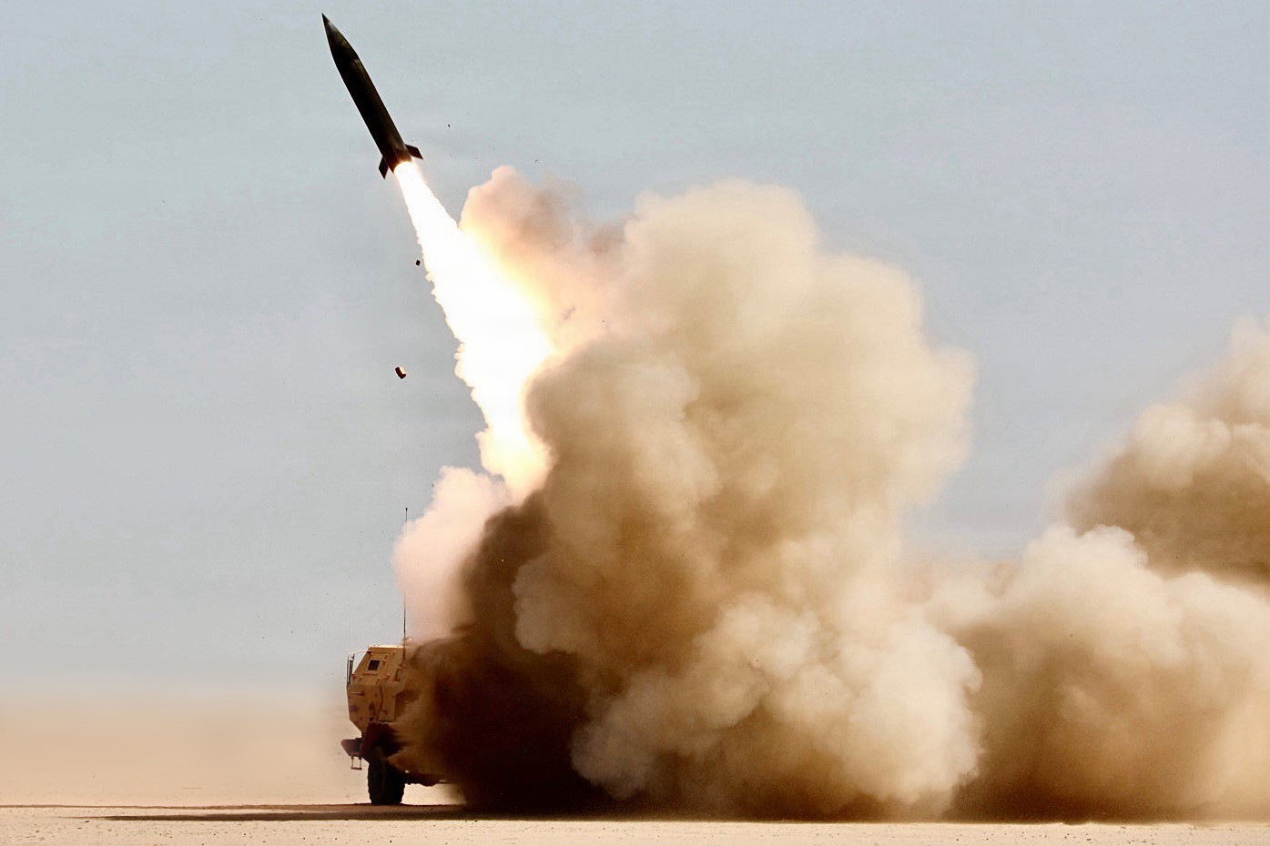 An M142 HIMARS launcher fires a rocket in a desert during Operation Epic Fury