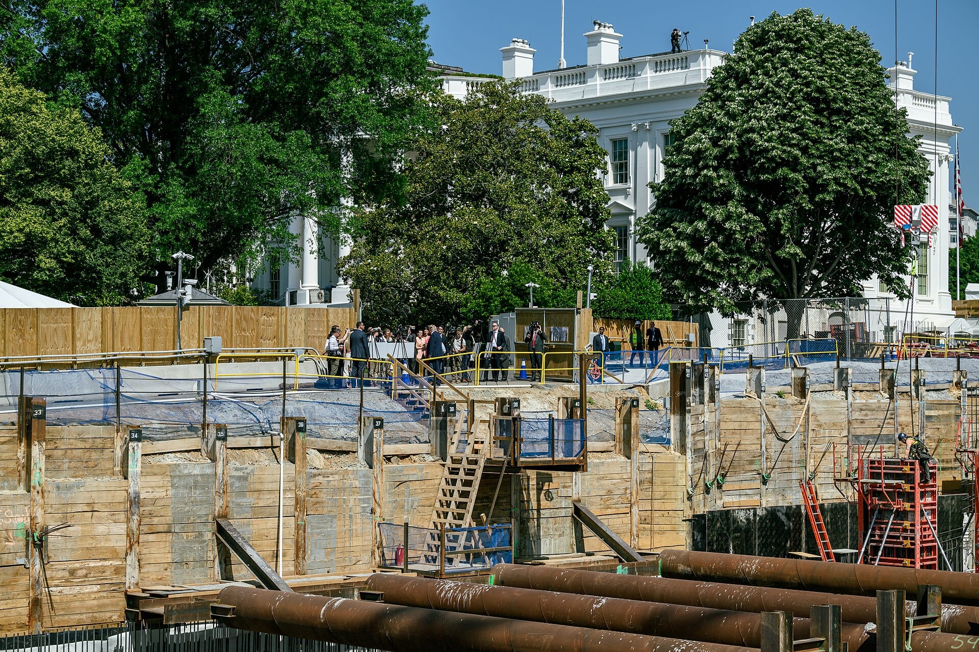 President Donald Trump speaks with reporters beside construction of the White House ballroom on the demolished East Wing site