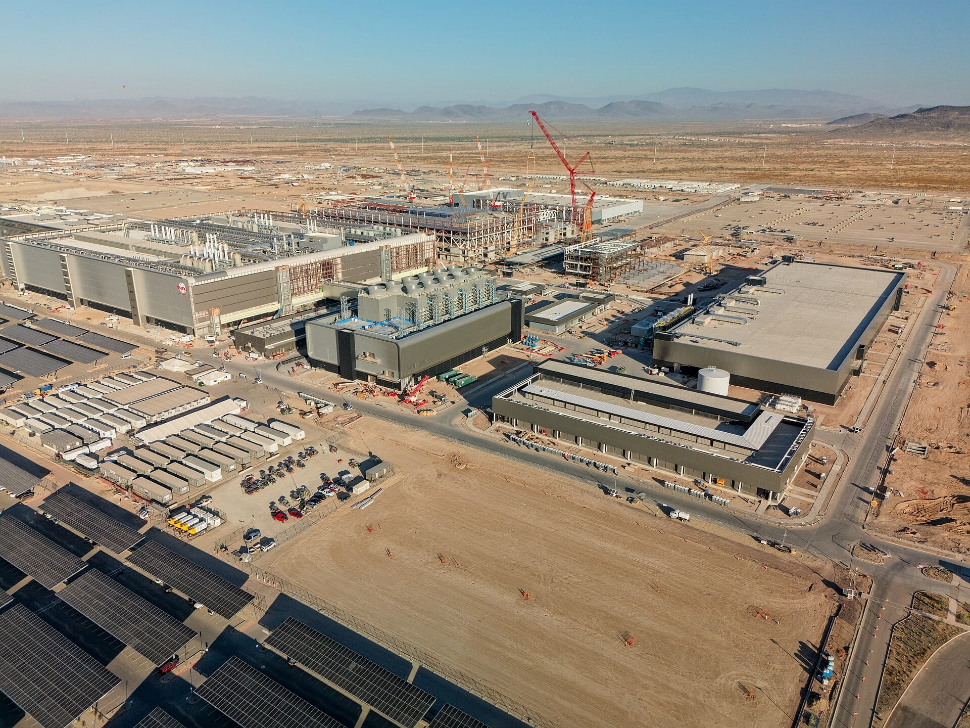 Aerial view of TSMC's Fab 21 site in Phoenix, Arizona under construction, with tower cranes still working on the next building