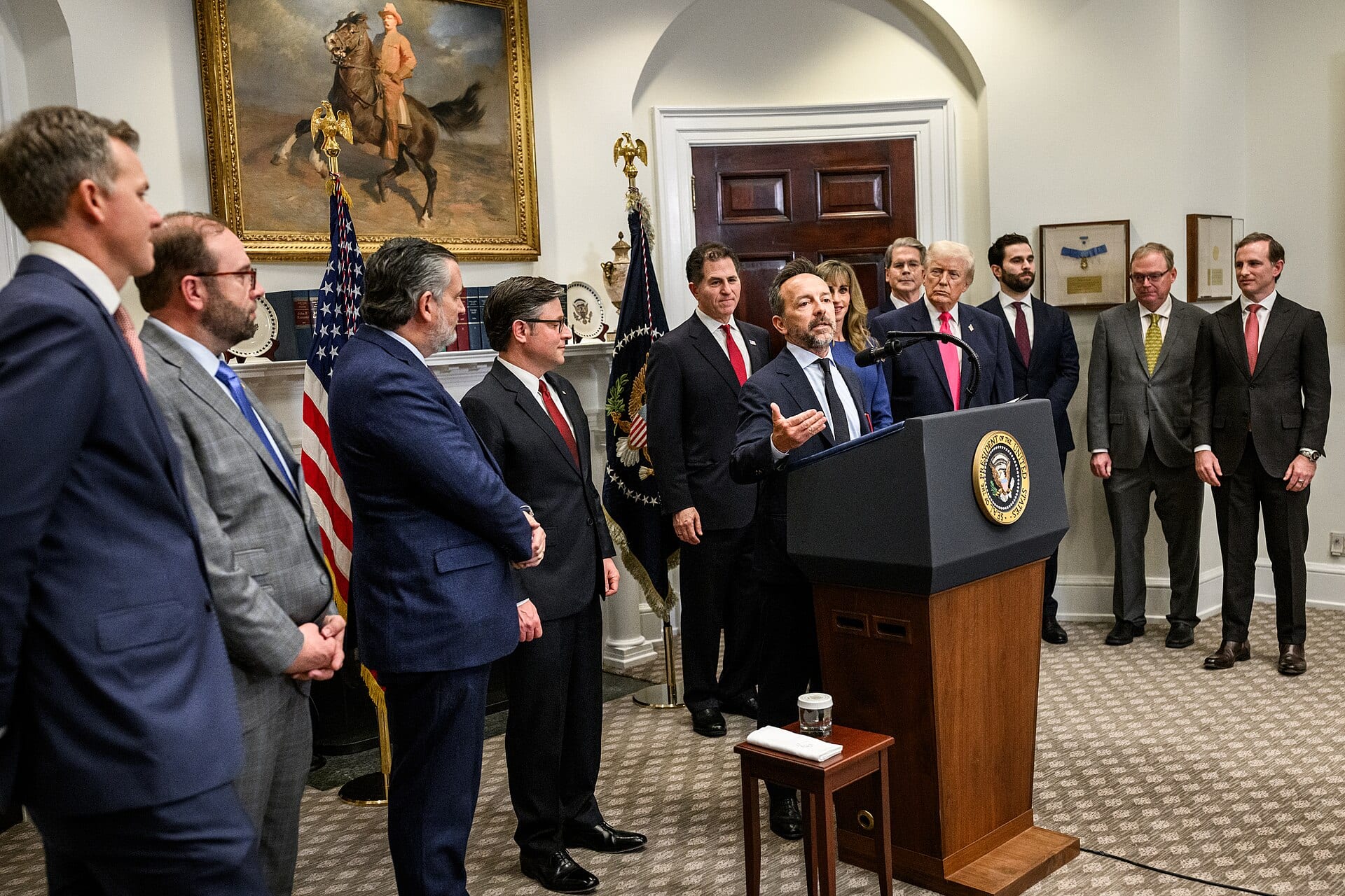 Michael Dell speaking at a podium in the White House Roosevelt Room