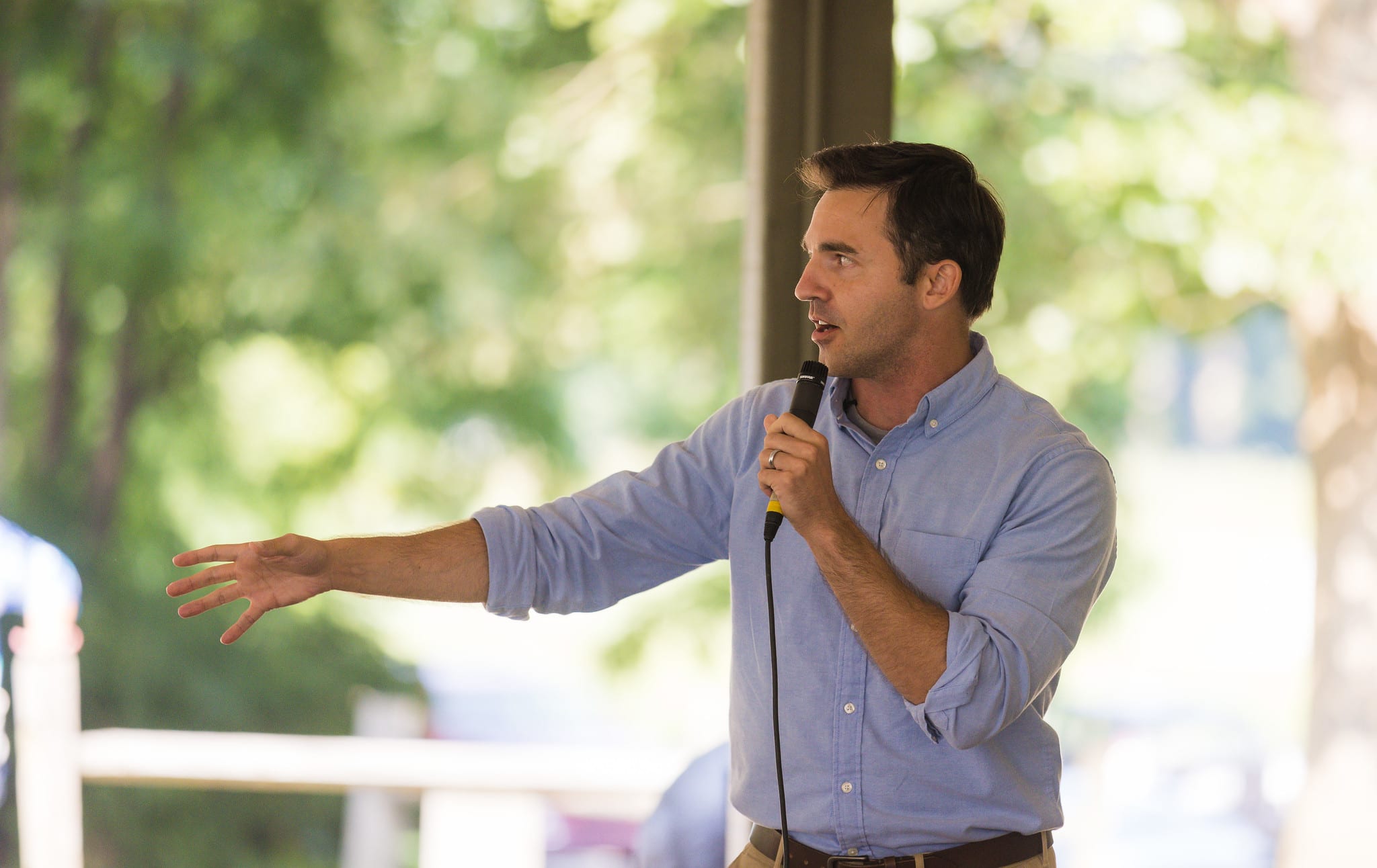 Jeff Jackson, North Carolina's attorney general, speaking with a microphone at a public forum