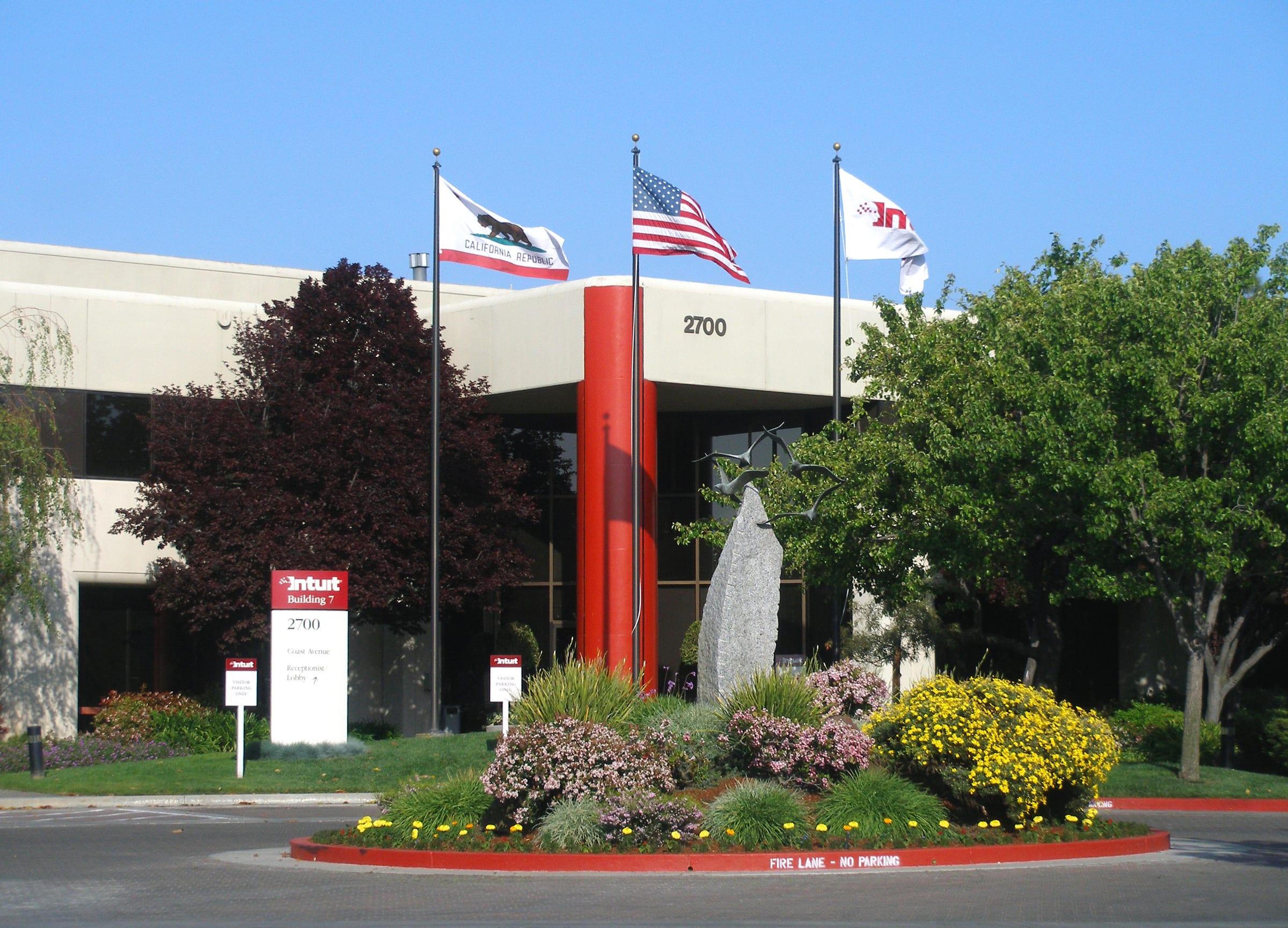 Intuit's headquarters building in Mountain View, California, with the company sign, flags and entrance plaza
