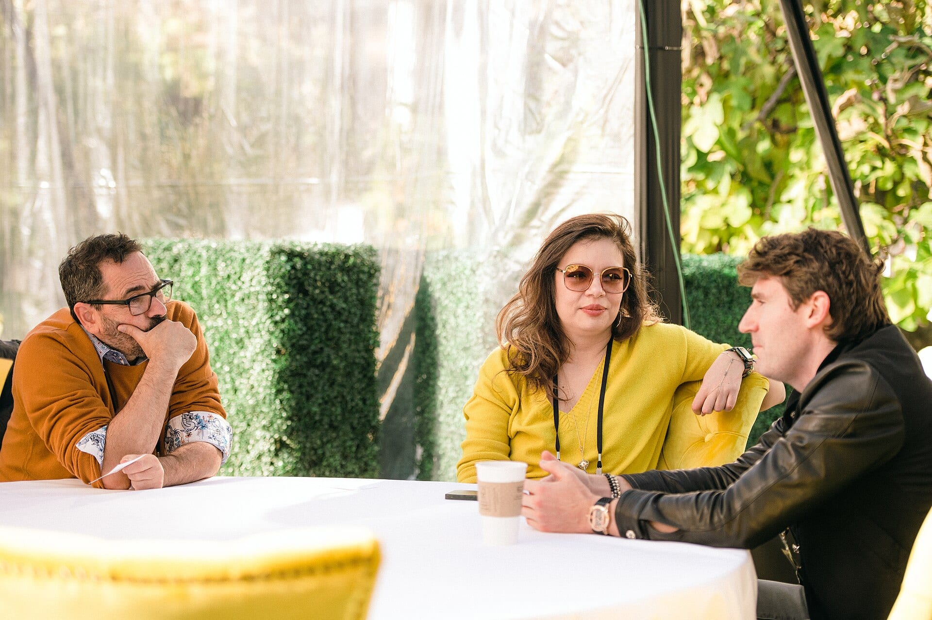 Cerebras chief executive Andrew Feldman, in glasses and a mustard sweater, listens across a table at a panel discussion with two other people