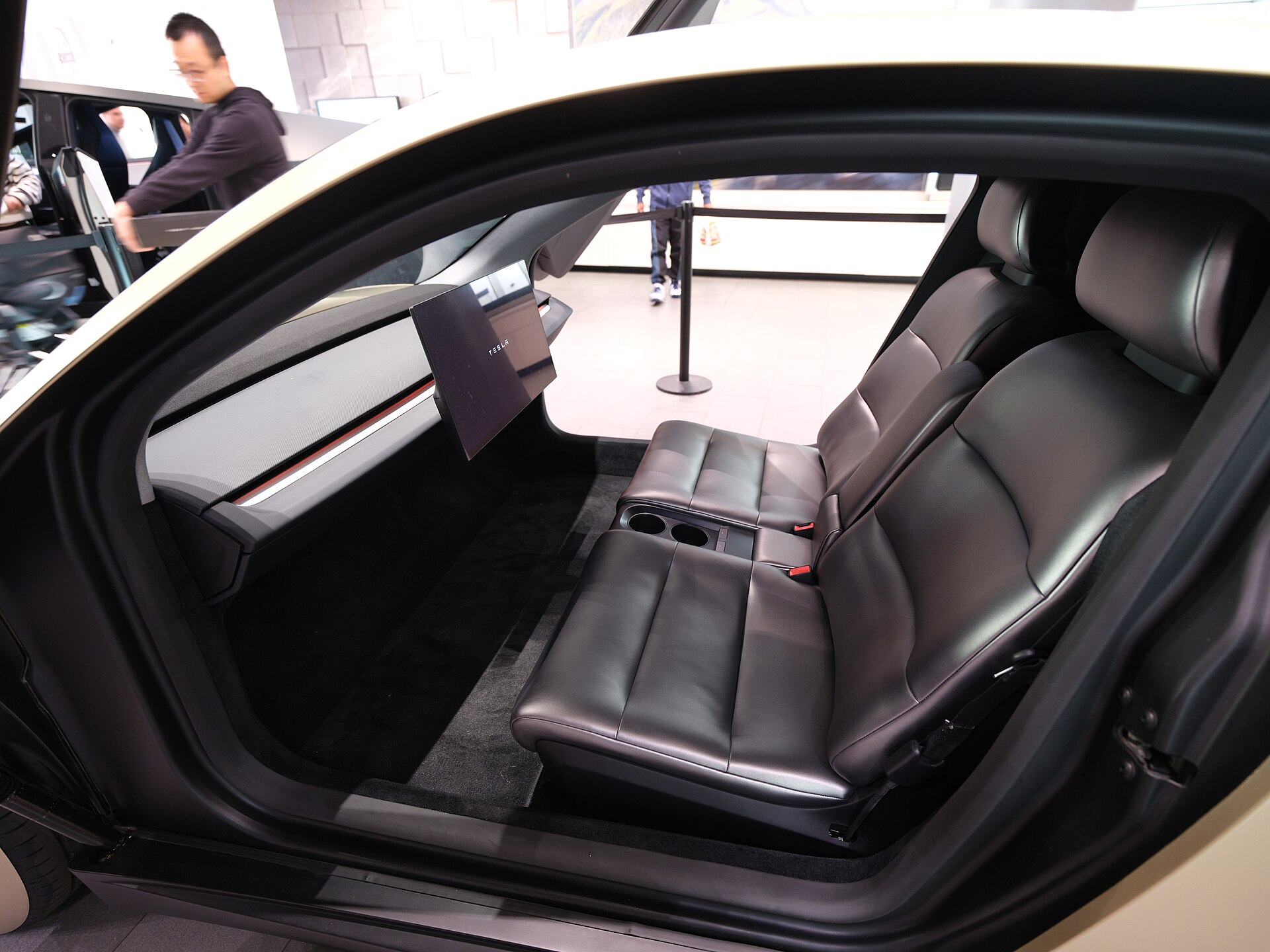 The interior of a Tesla Cybercab, with two bench seats and a central display and no steering wheel or pedals