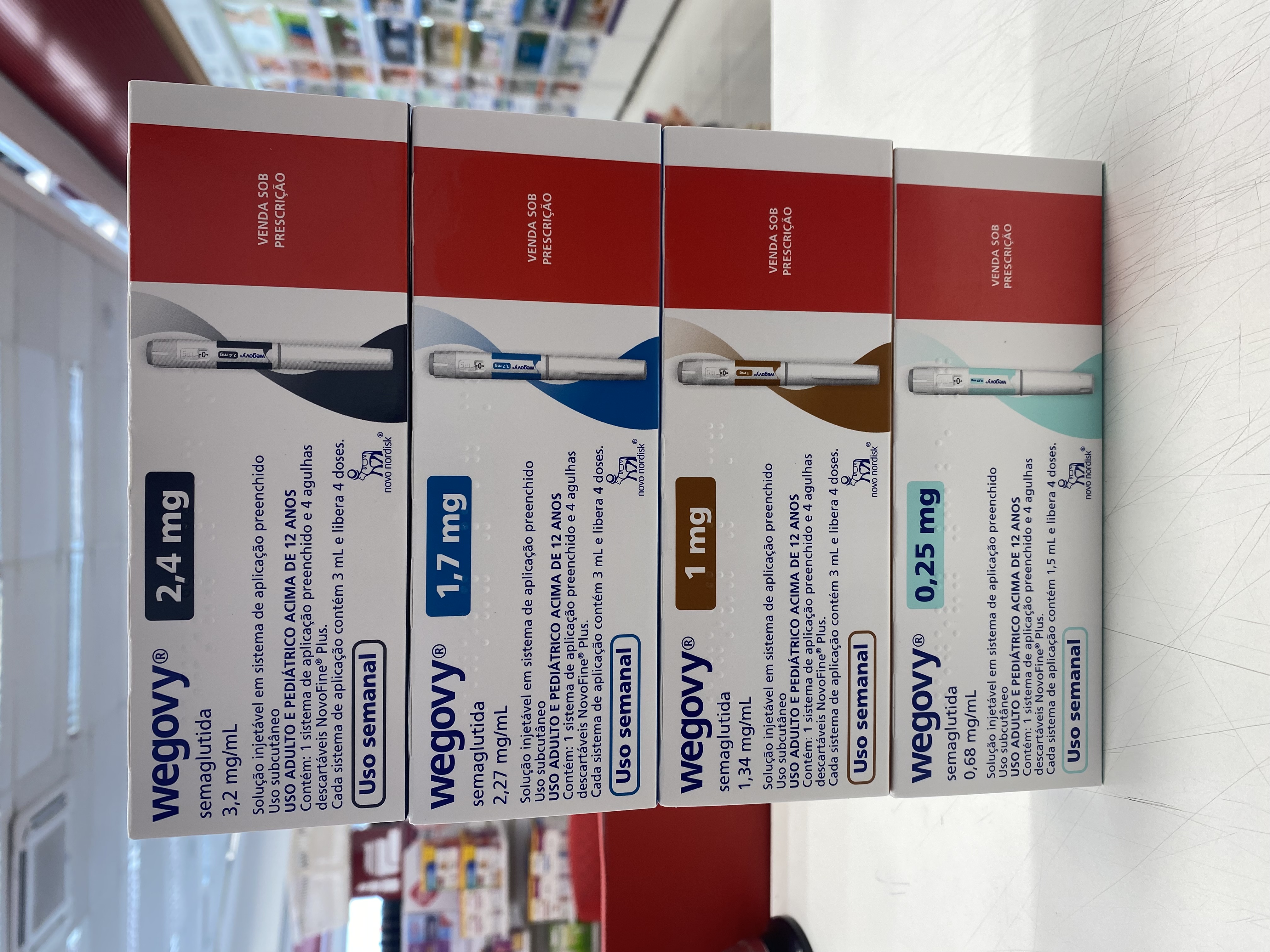 Quatro caixas de canetas injetáveis de Wegovy (semaglutida), da Novo Nordisk, em doses diferentes, empilhadas no balcão de uma farmácia