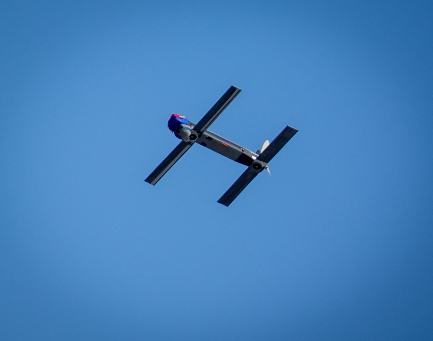 A Switchblade 300 loitering munition in flight against a clear blue sky