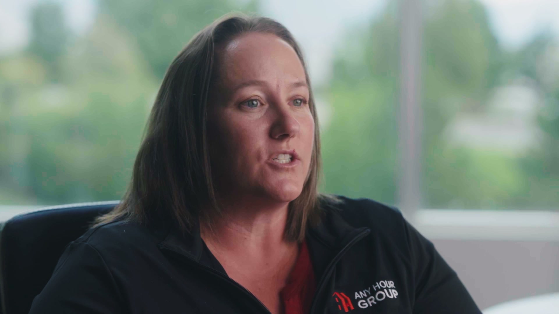 A woman in an Any Hour Group jacket speaking during an interview
