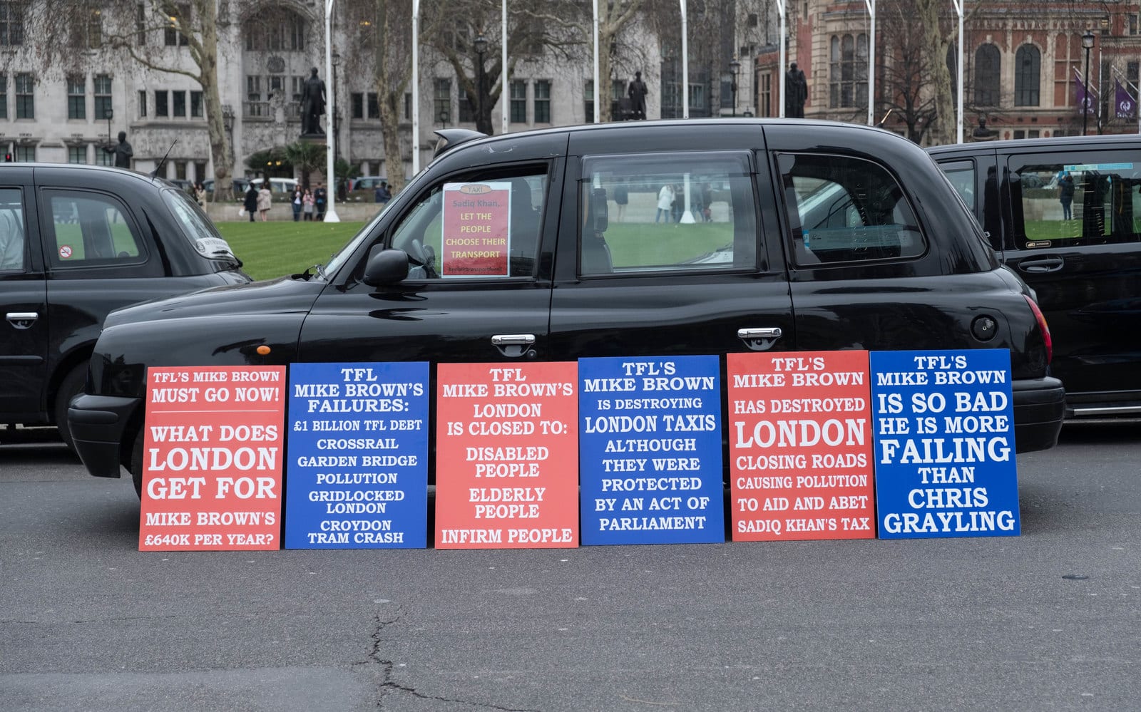 London black cabs and protest placards aimed at Transport for London in Parliament Square
