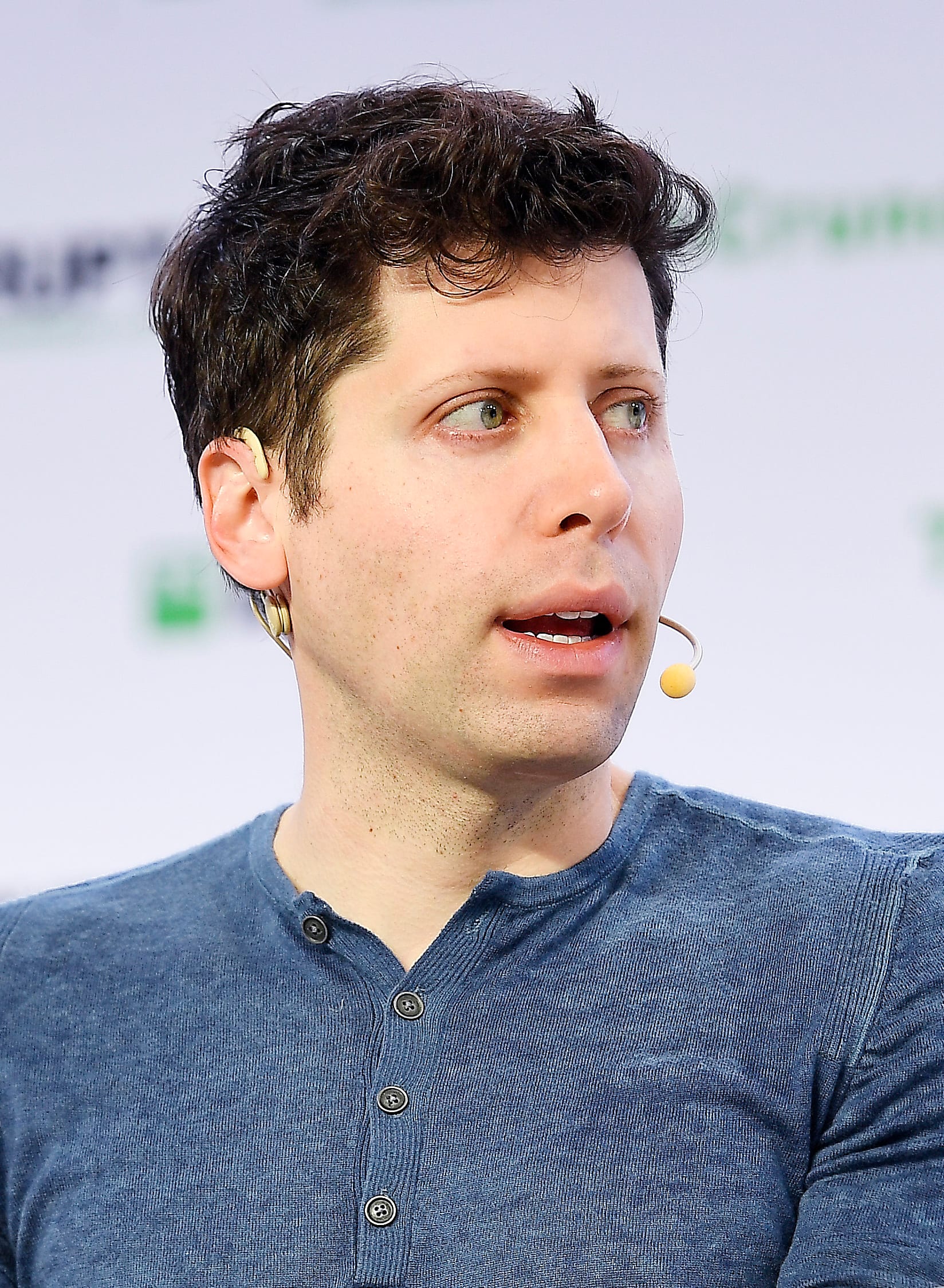 Sam Altman speaking on a panel headset