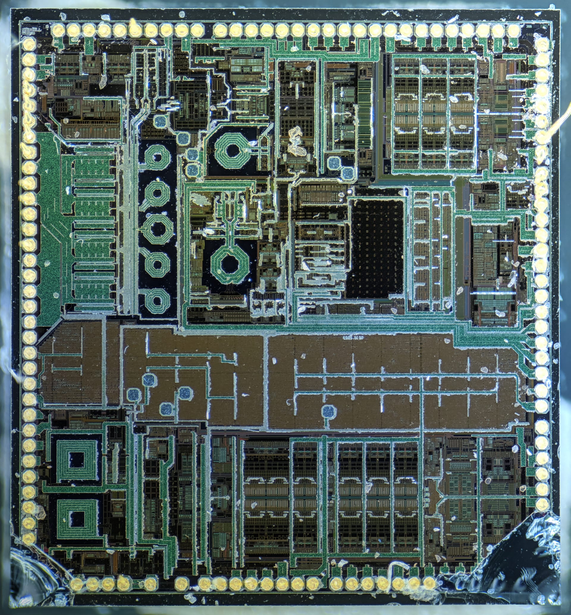 Macro photograph of a Marvell silicon die, showing its internal circuit blocks and bond pads around the edges.