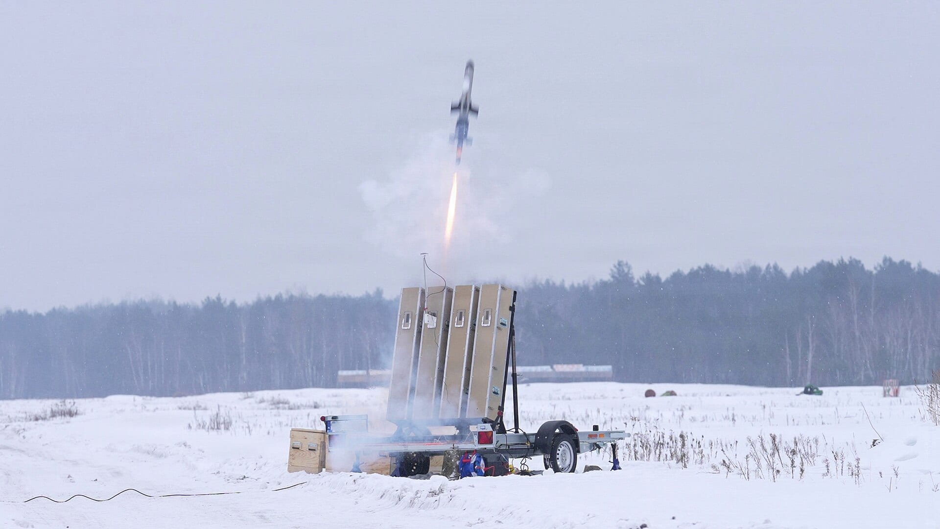 An IonStrike interceptor launches from a multi-launcher array in a snowy field during a U.S. Army test event in Europe