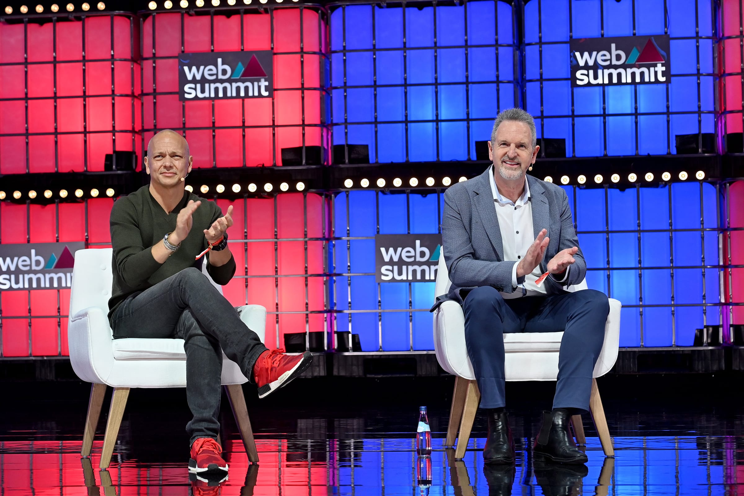 Arm CEO Rene Haas, right, gestures while speaking on a Web Summit stage beside Tony Fadell in November 2022.