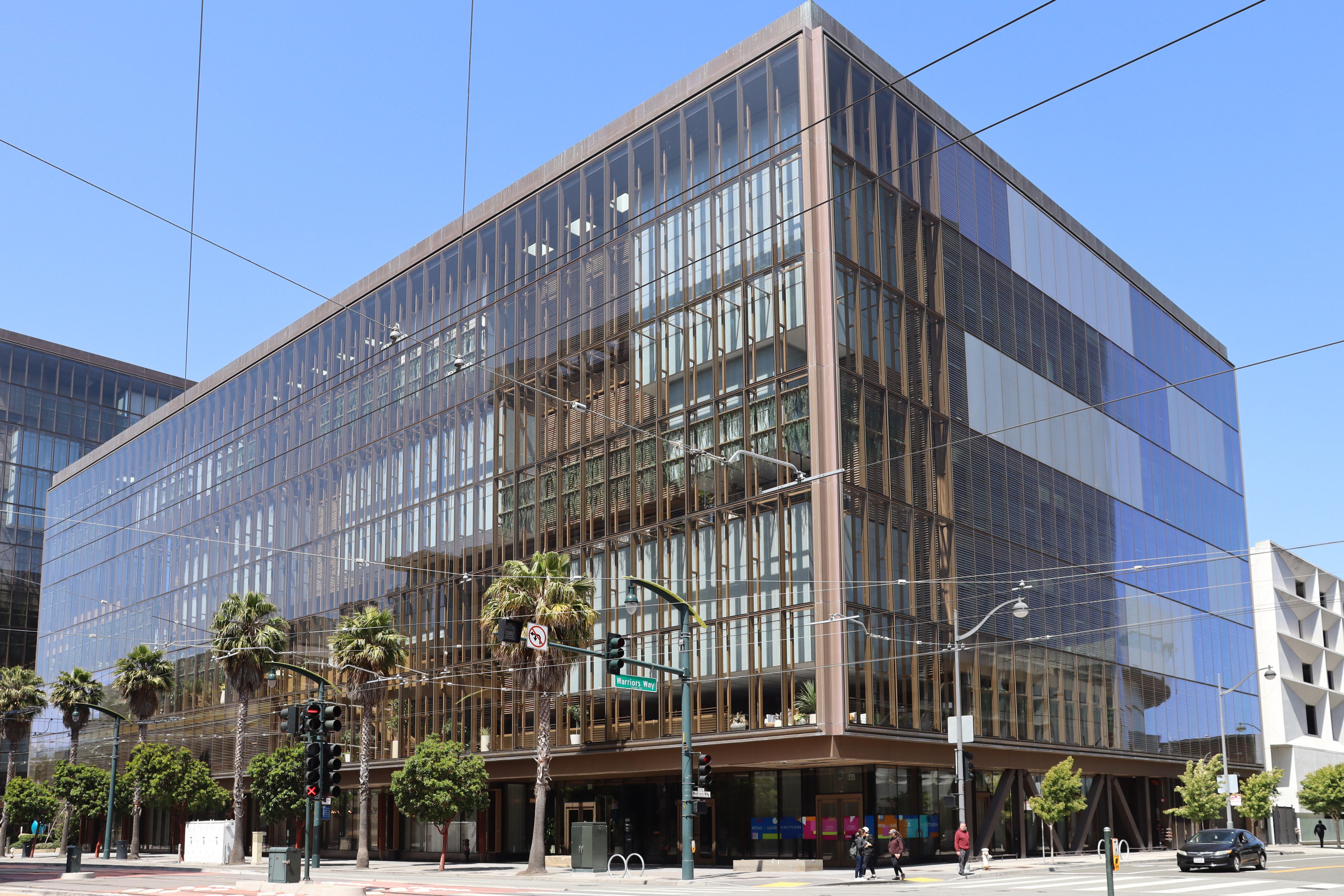 The glass facade of 1515 Third Street, OpenAI's headquarters building in San Francisco's Mission Bay neighborhood, seen from the corner of Warriors Way.