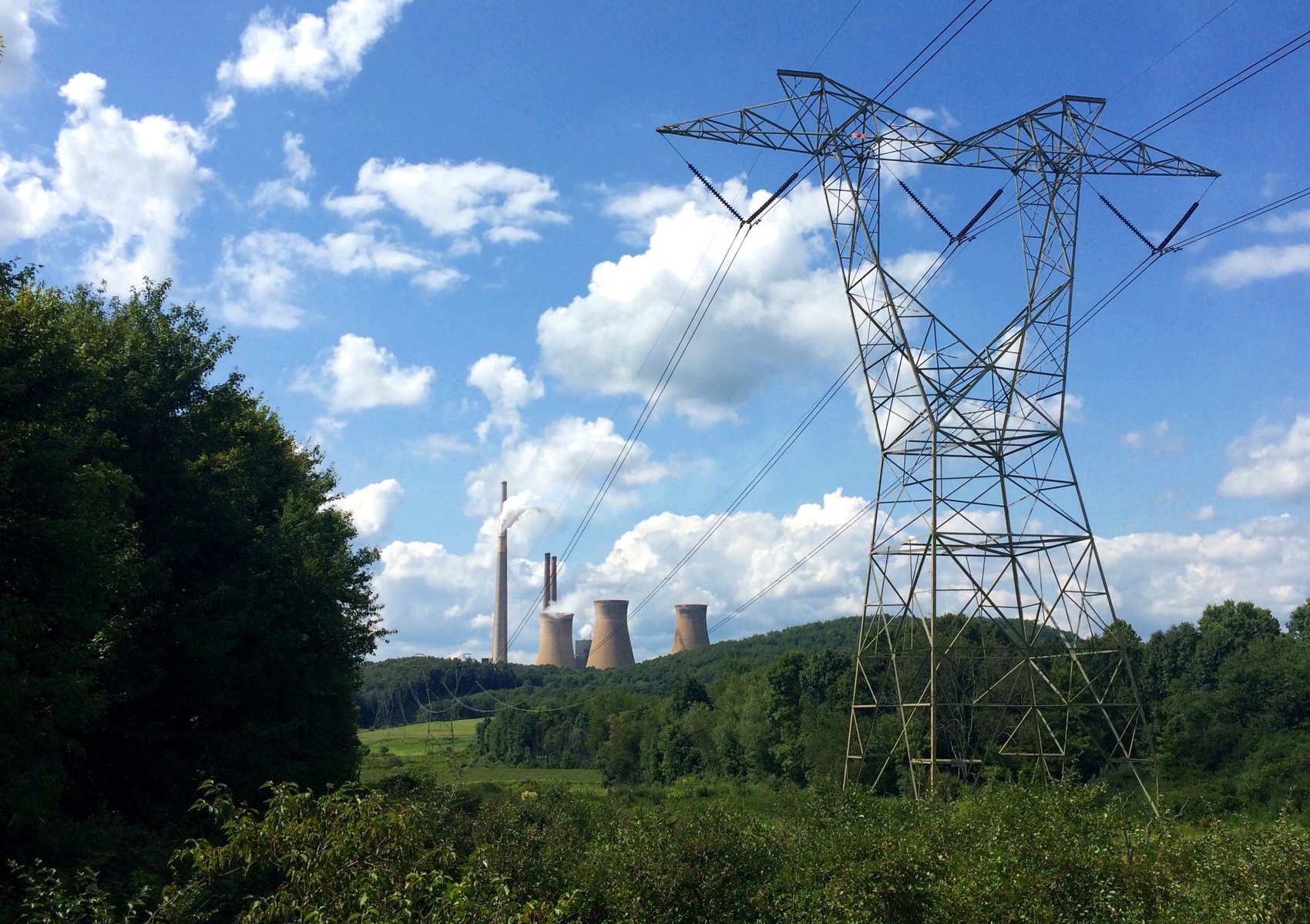 The Homer City Generating Station's smokestacks and cooling towers seen from US Route 119 in 2018, behind a high-voltage transmission tower