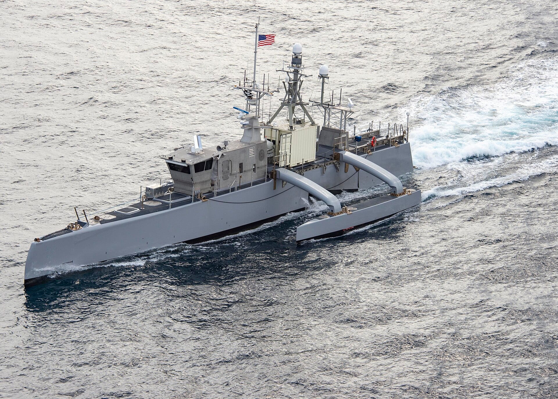 The U.S. Navy unmanned surface vessel Sea Hunter underway at sea during RIMPAC 2022, flying a U.S. flag.