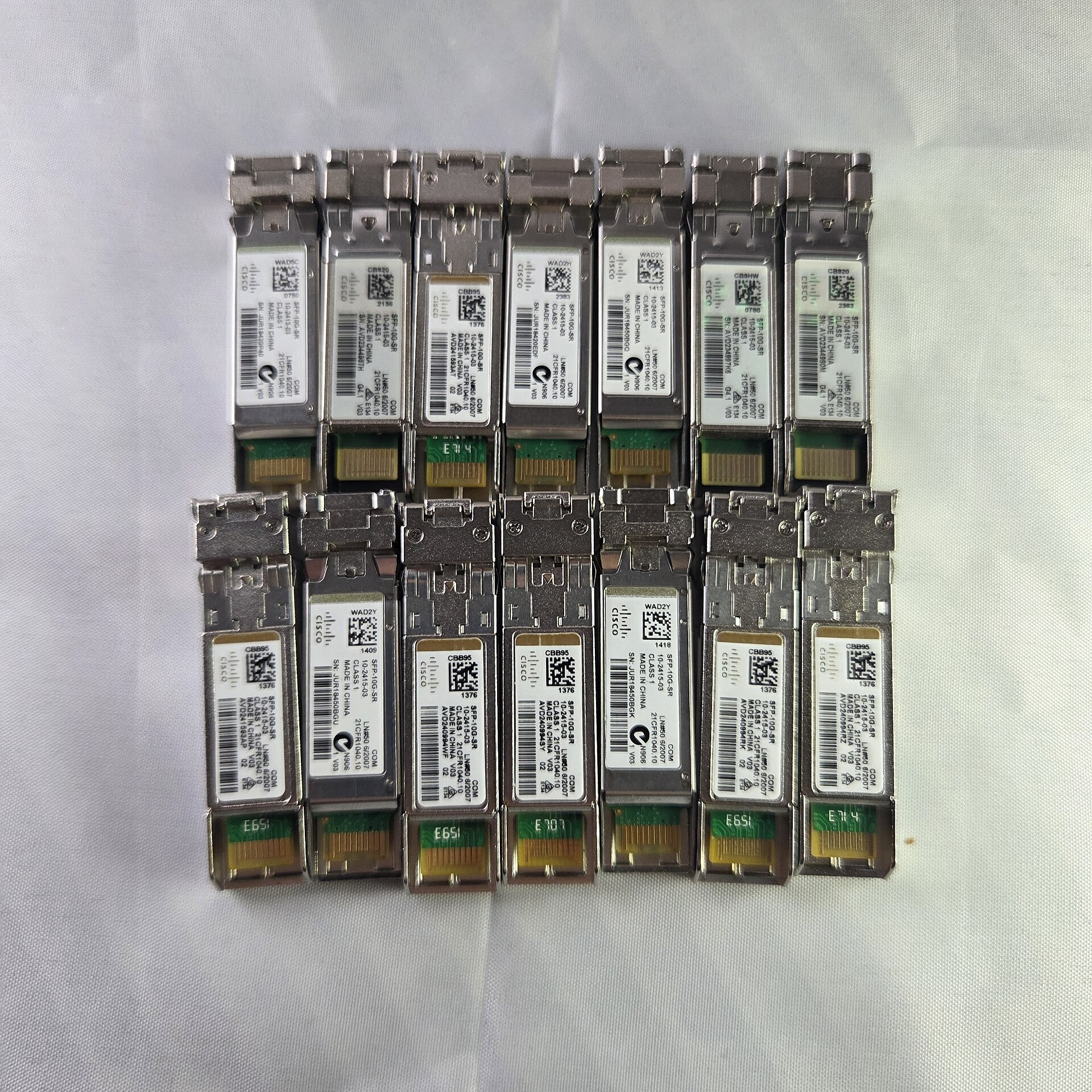 Cisco SFP-10G-SR optical transceiver modules laid out on a white sheet