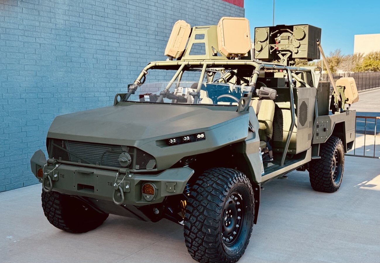 A US Army M1301 Infantry Squad Vehicle fitted with a LOCUST laser weapon system, parked outside a hangar at Fort Sill.