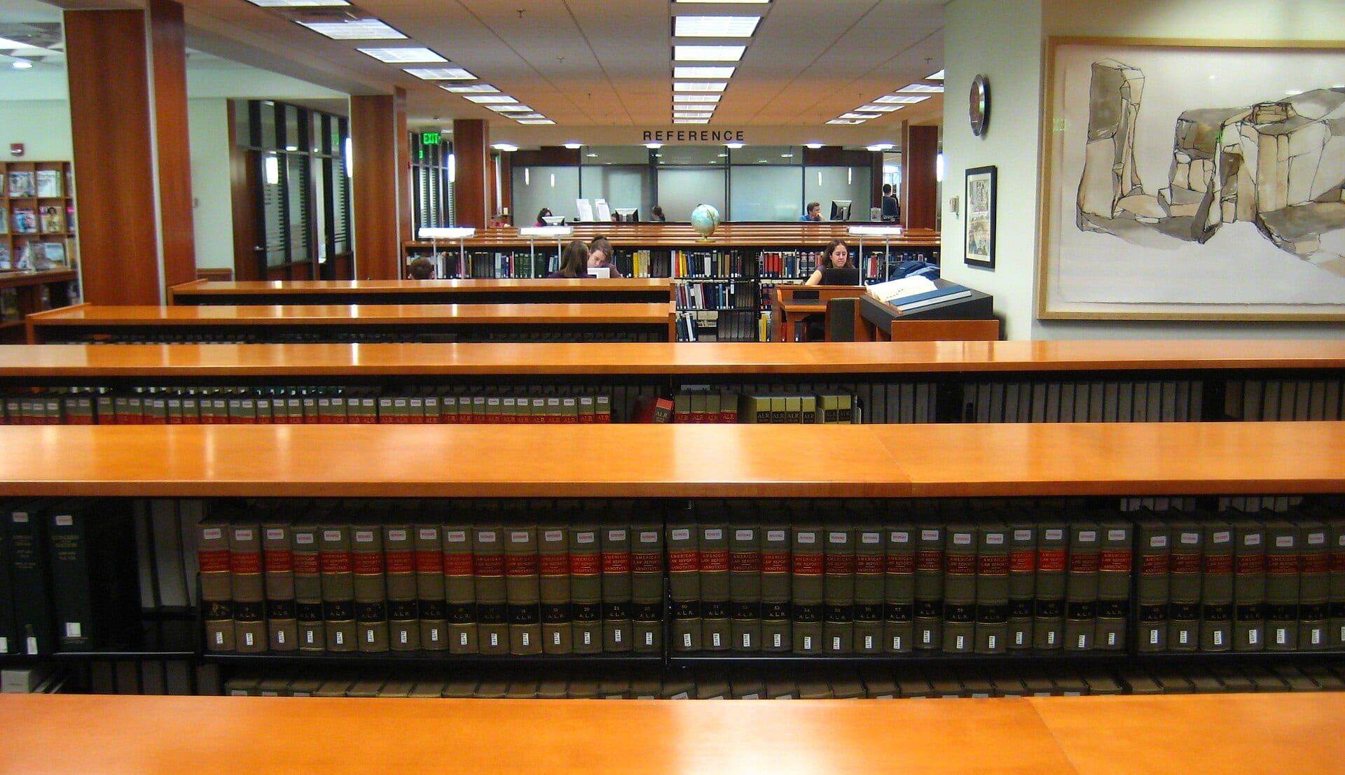 The reading room of a law library, with shelves of case reporters and researchers at work