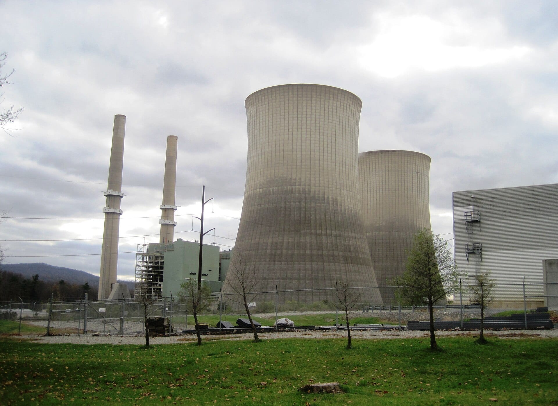 The Martins Creek power plant in Pennsylvania, its two concrete cooling towers and smokestacks rising behind a chain-link fence.