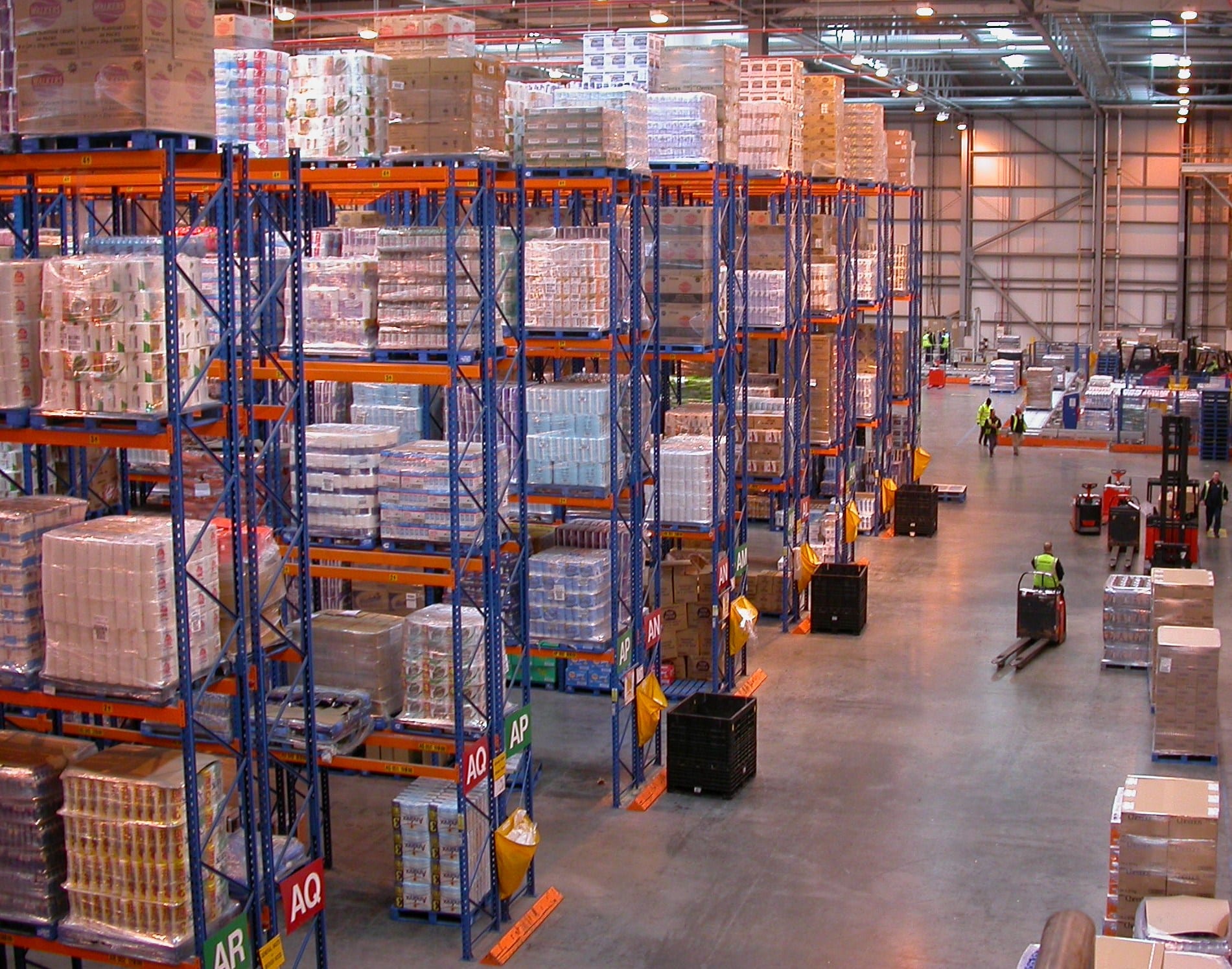 Racked goods and forklifts inside a large British distribution centre