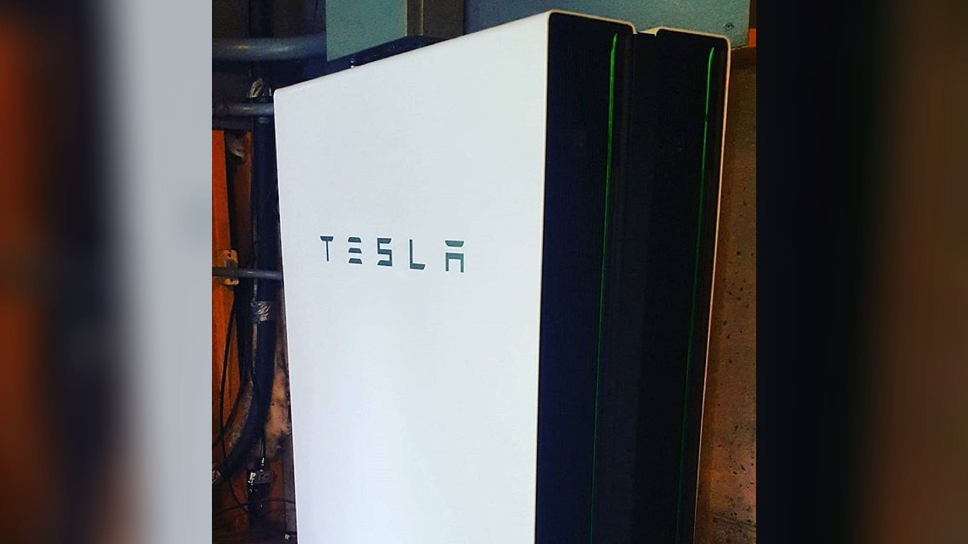 A Tesla Powerwall home battery installed on a garage wall
