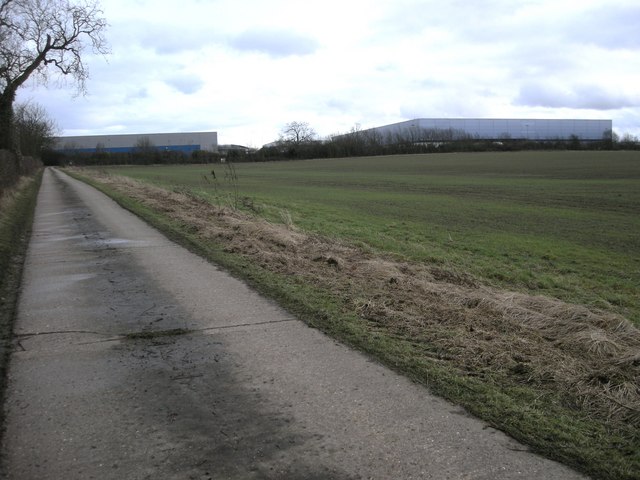Warehouse sheds at Magna Park seen across fields from a country lane