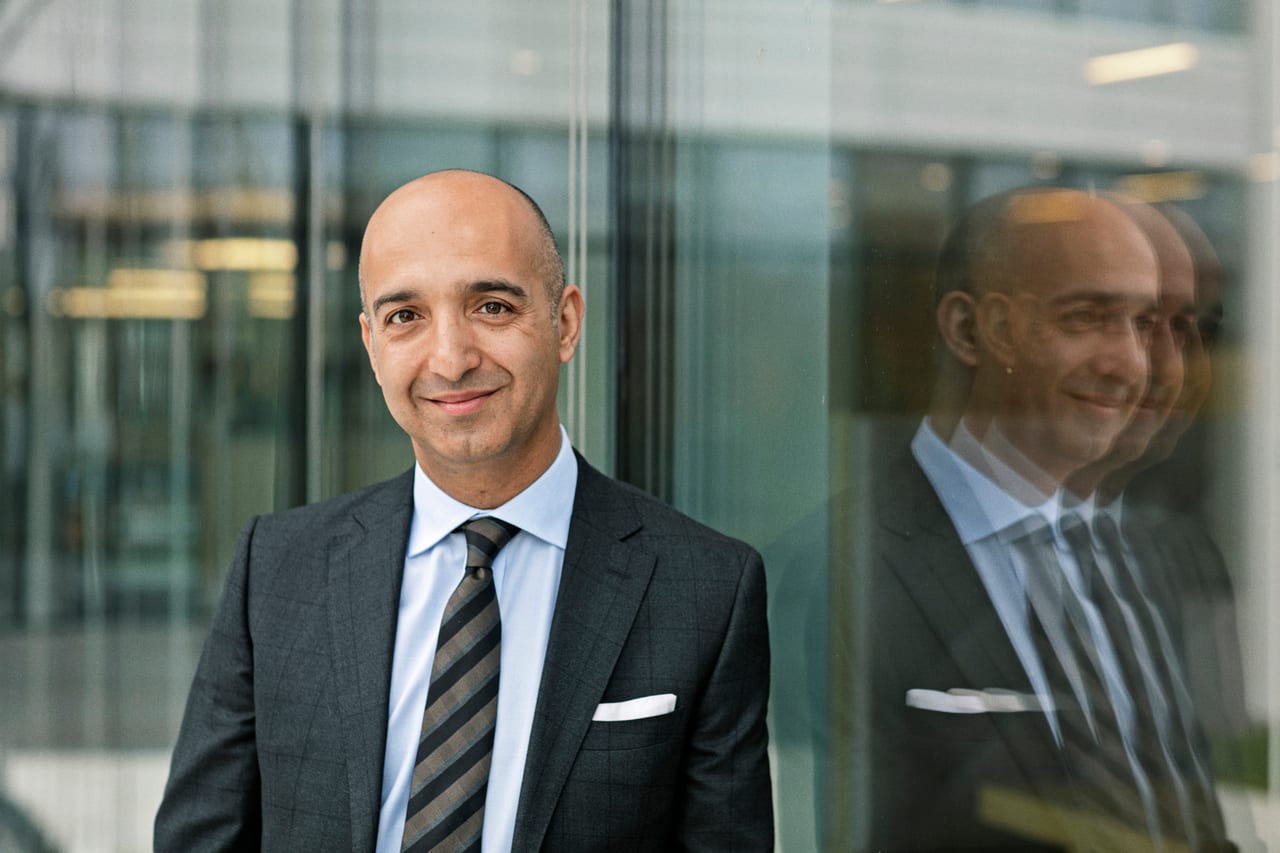 Novo Nordisk chief executive Mike Doustdar in a grey suit in front of a glass wall