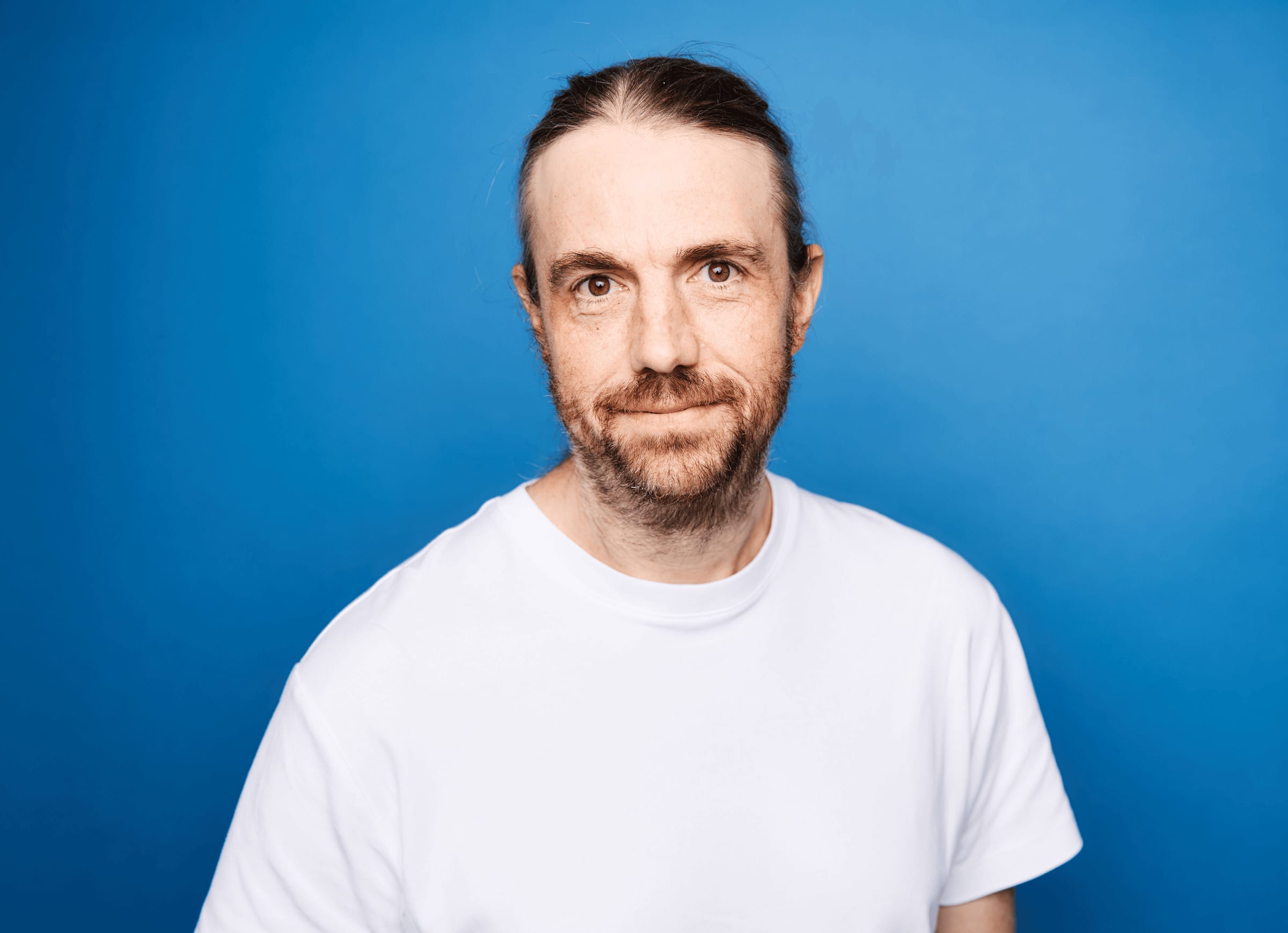 Mike Cannon-Brookes, chief executive of Atlassian, in a white t-shirt against a blue backdrop