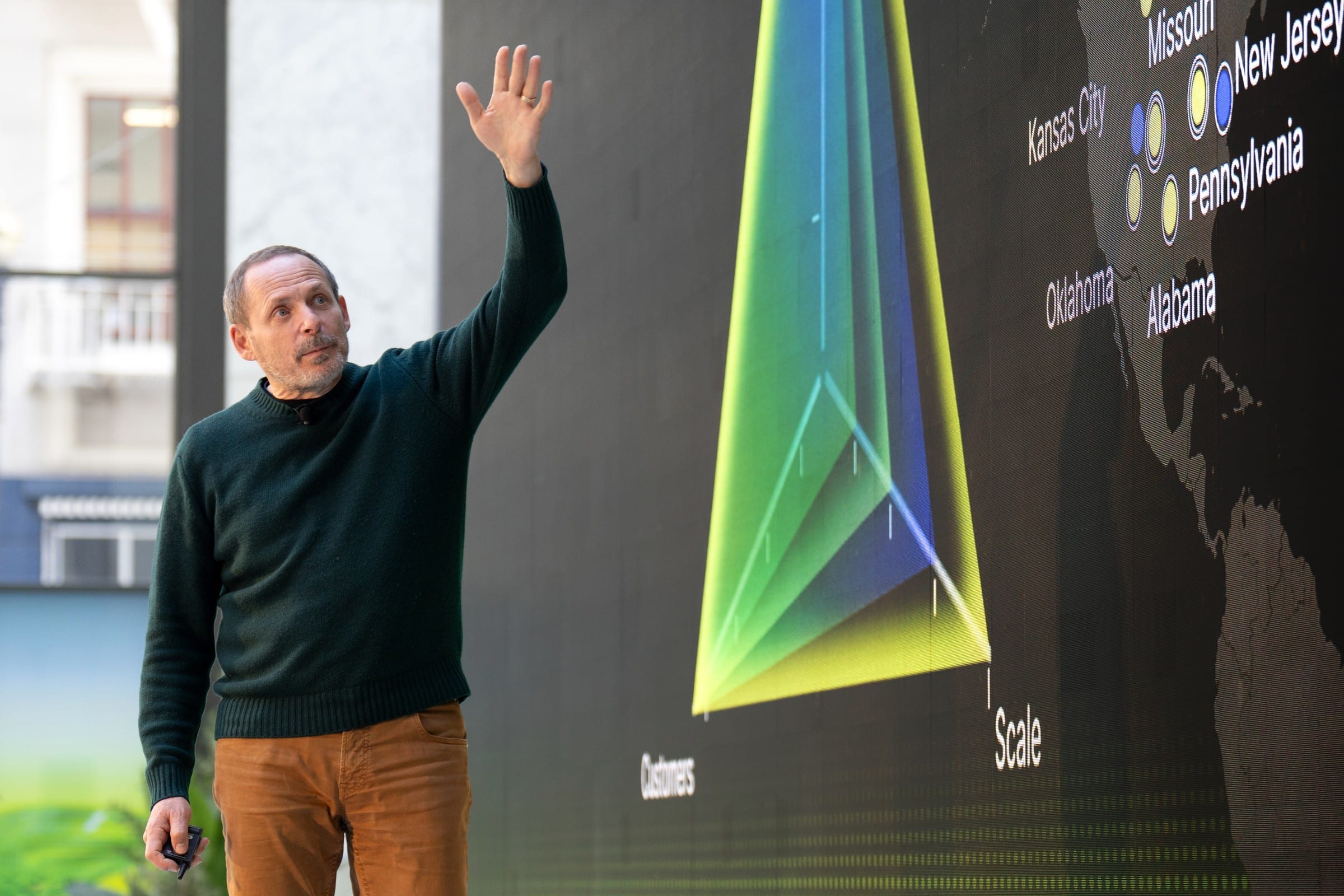 Arkady Volozh, Nebius founder and chief executive, presenting on stage in front of a map of the company's US data-centre sites