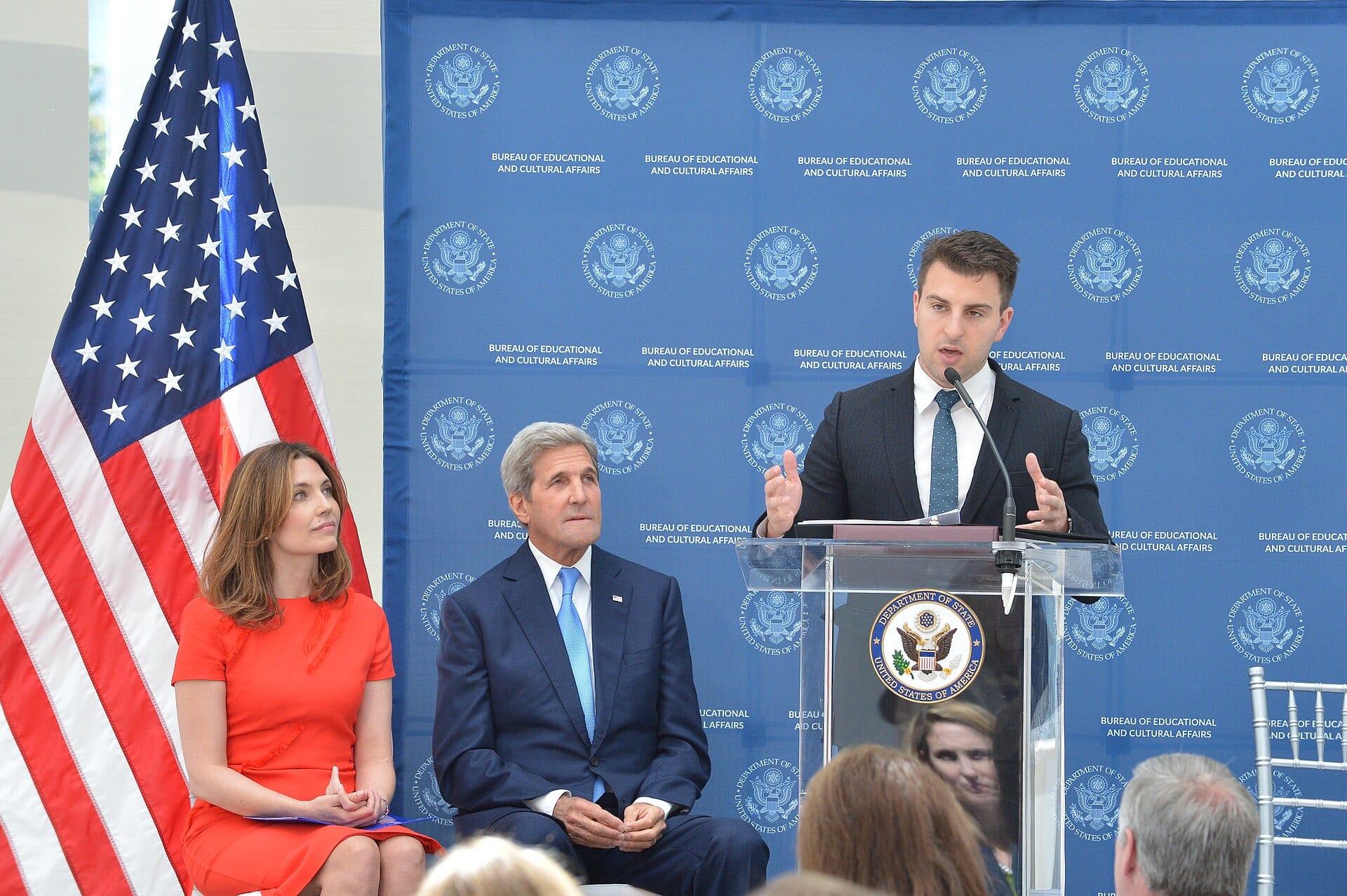 Brian Chesky, co-founder and chief executive of Airbnb, speaks at a lectern with a State Department banner behind him.