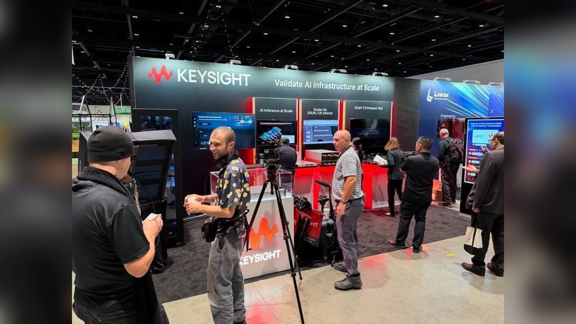 The Keysight booth at the OCP Global Summit 2026 in San Jose, with demonstration stations for AI inference validation, scale-up ESUN and UE interconnect testing, and PCIe 7.0 protocol test under a banner reading Validate AI Infrastructure at Scale.