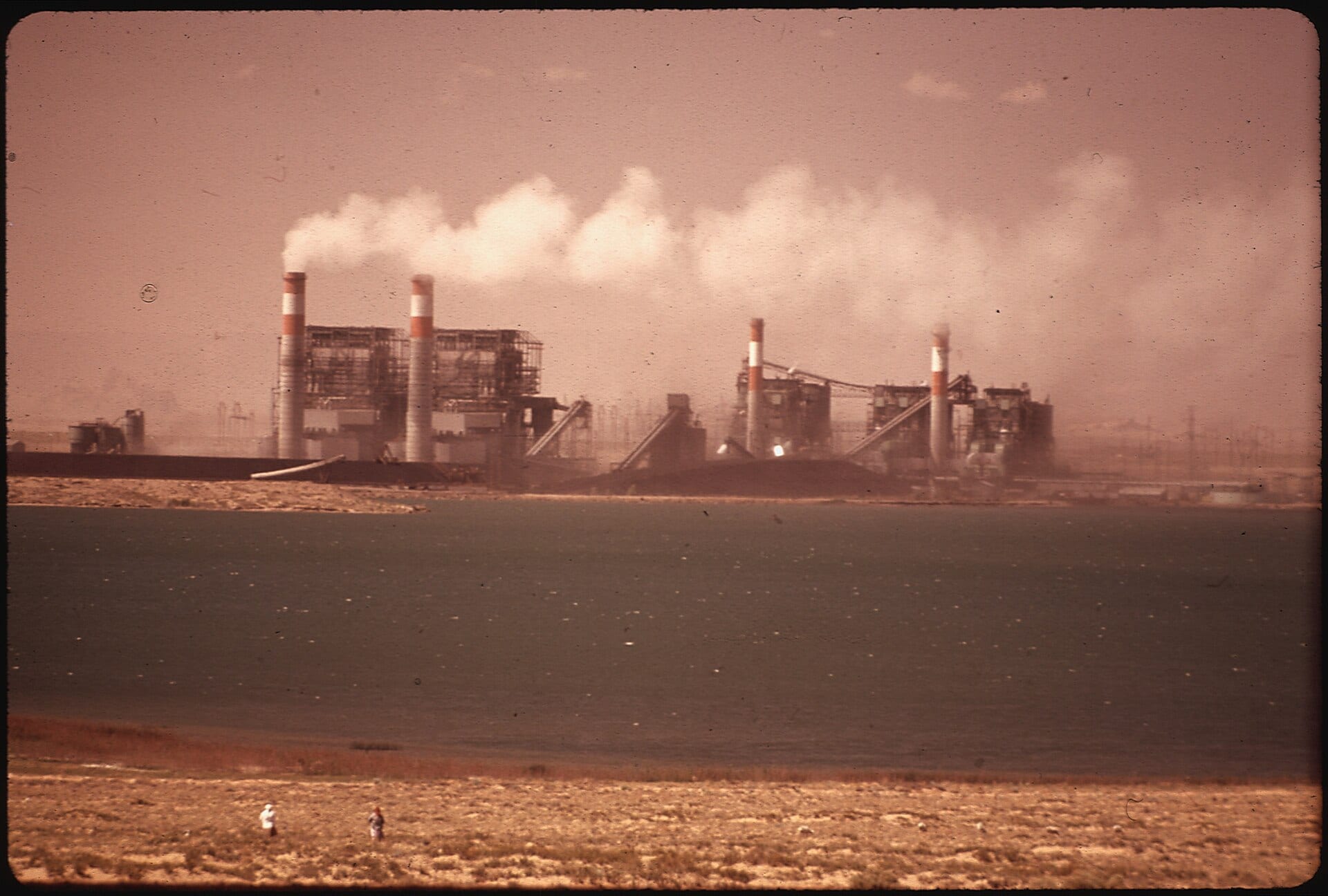 Four Corners Power Plant at dusk in May 1972, its stacks and buildings silhouetted against the sky
