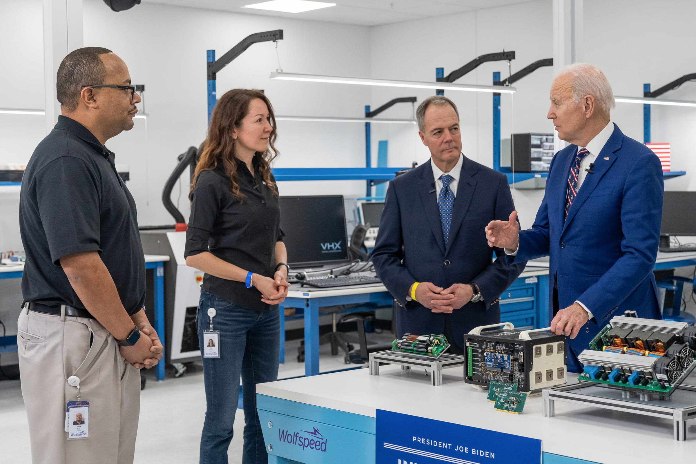 Wolfspeed's chief executive and engineers beside a bench of silicon carbide power modules marked with the Wolfspeed name, in its Durham, North Carolina, facility.