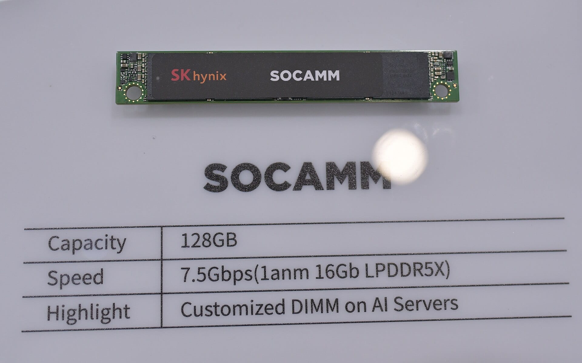 An SK Hynix SOCAMM memory module on display, the company's branding visible on the black module above a specification placard.
