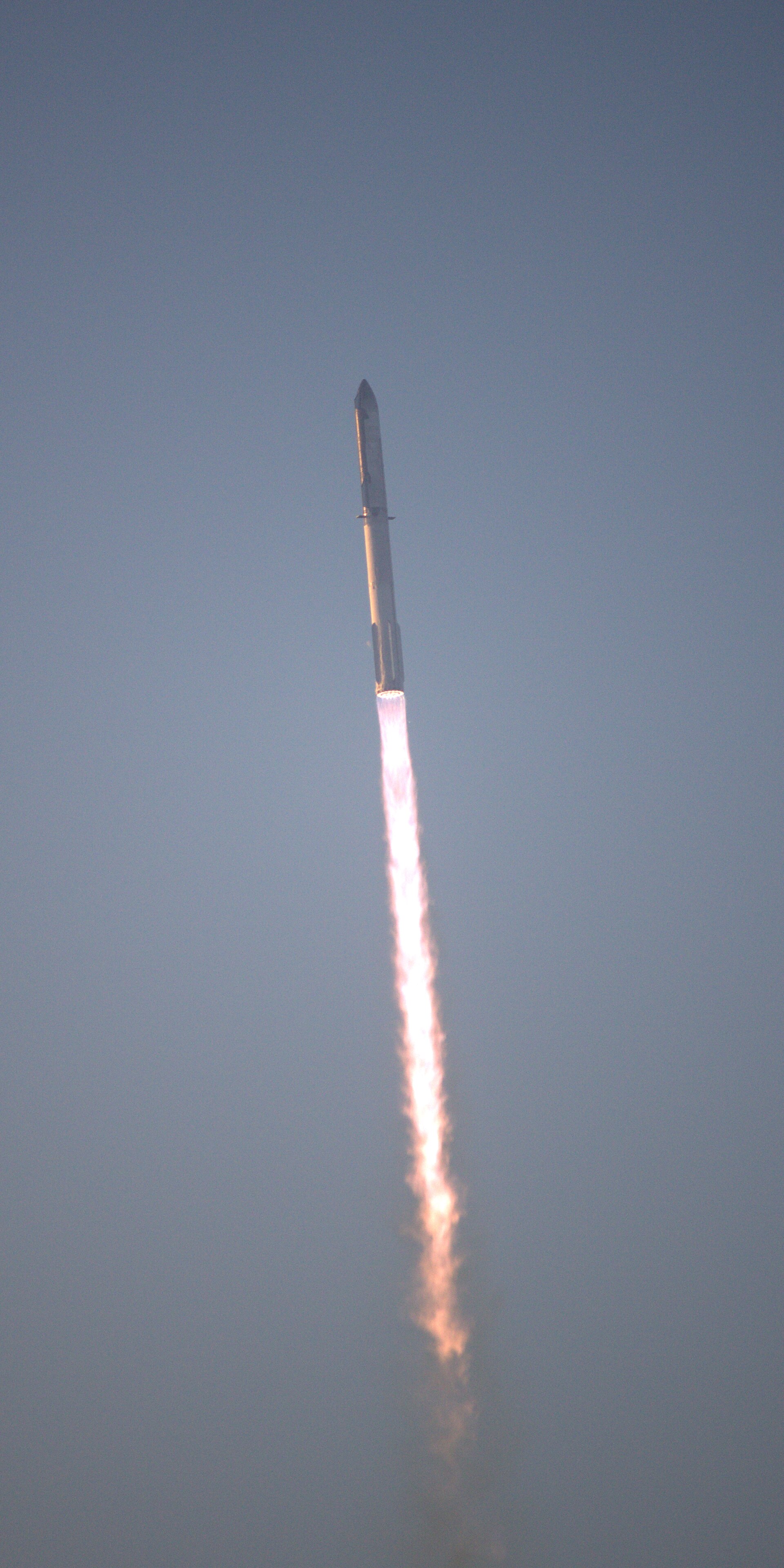SpaceX's Starship climbing through the sky on a pillar of flame during its second integrated flight test