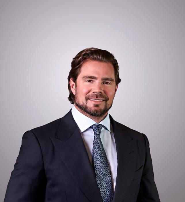 Studio portrait of Daniel Vorcaro in a dark suit and patterned tie