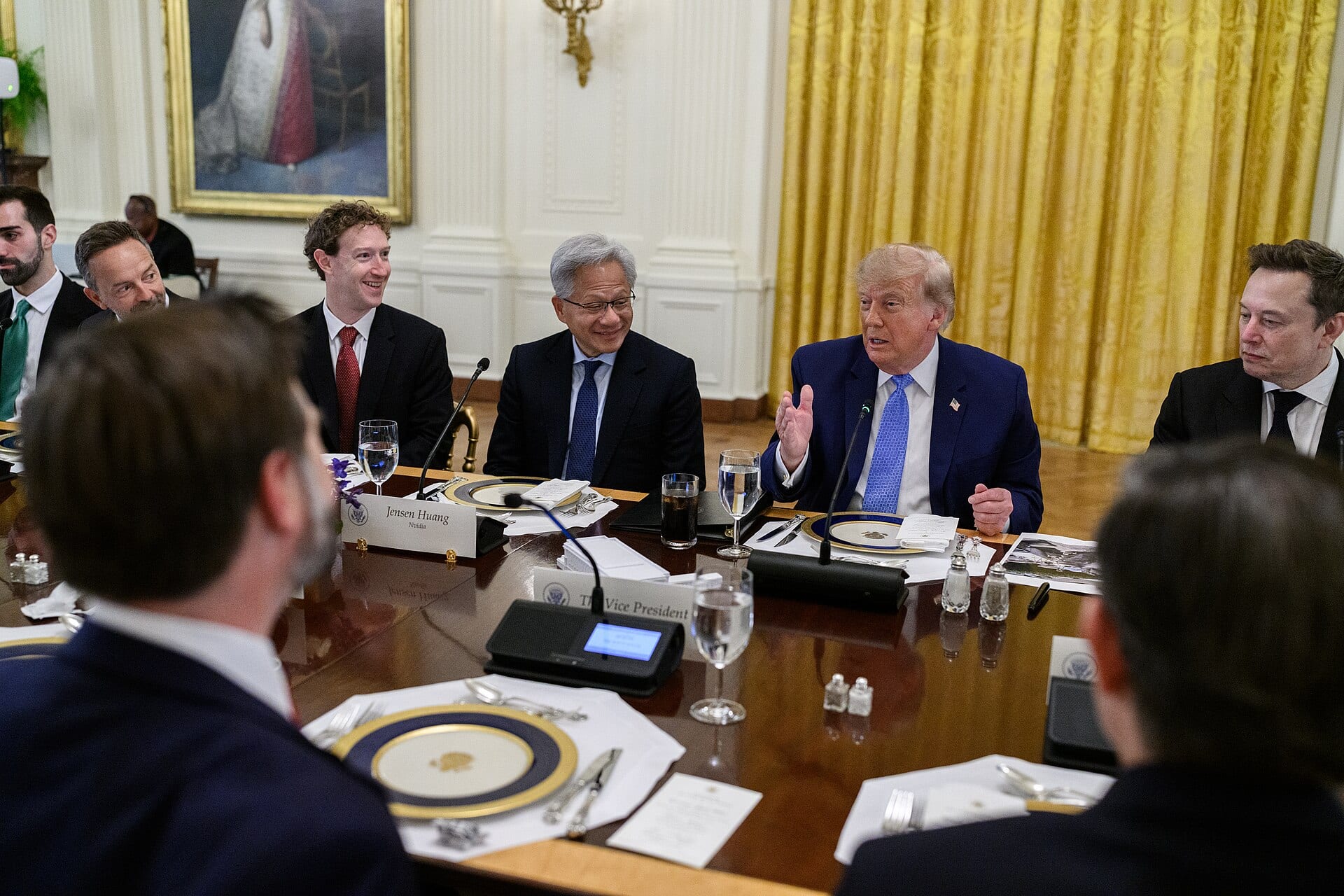 Mark Zuckerberg seated beside Nvidia's Jensen Huang as President Trump speaks at a White House luncheon on artificial intelligence