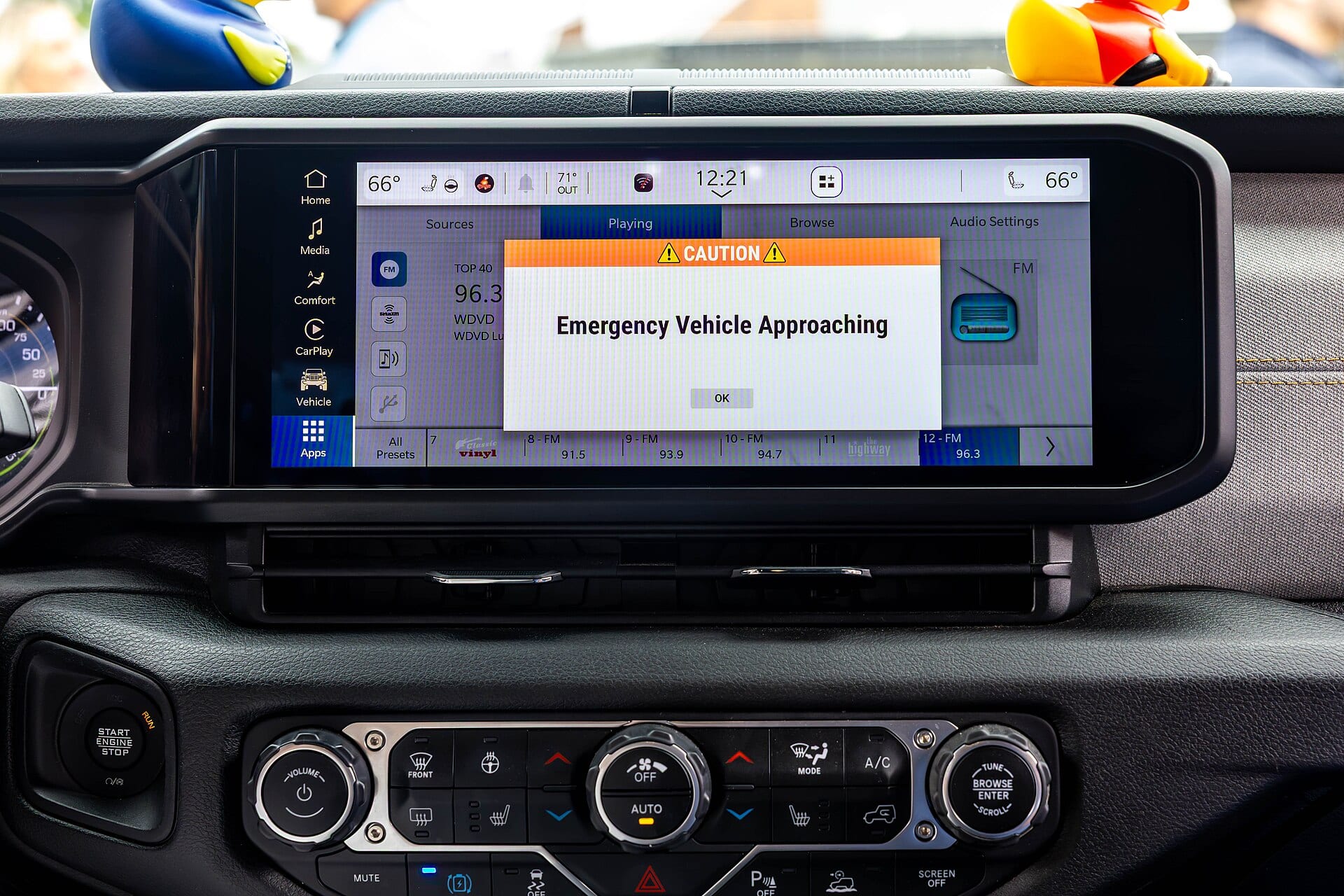 A connected-car dashboard screen running FM radio, showing the station 96.3 WDVD and preset buttons, photographed during a vehicle technology demonstration in Detroit.