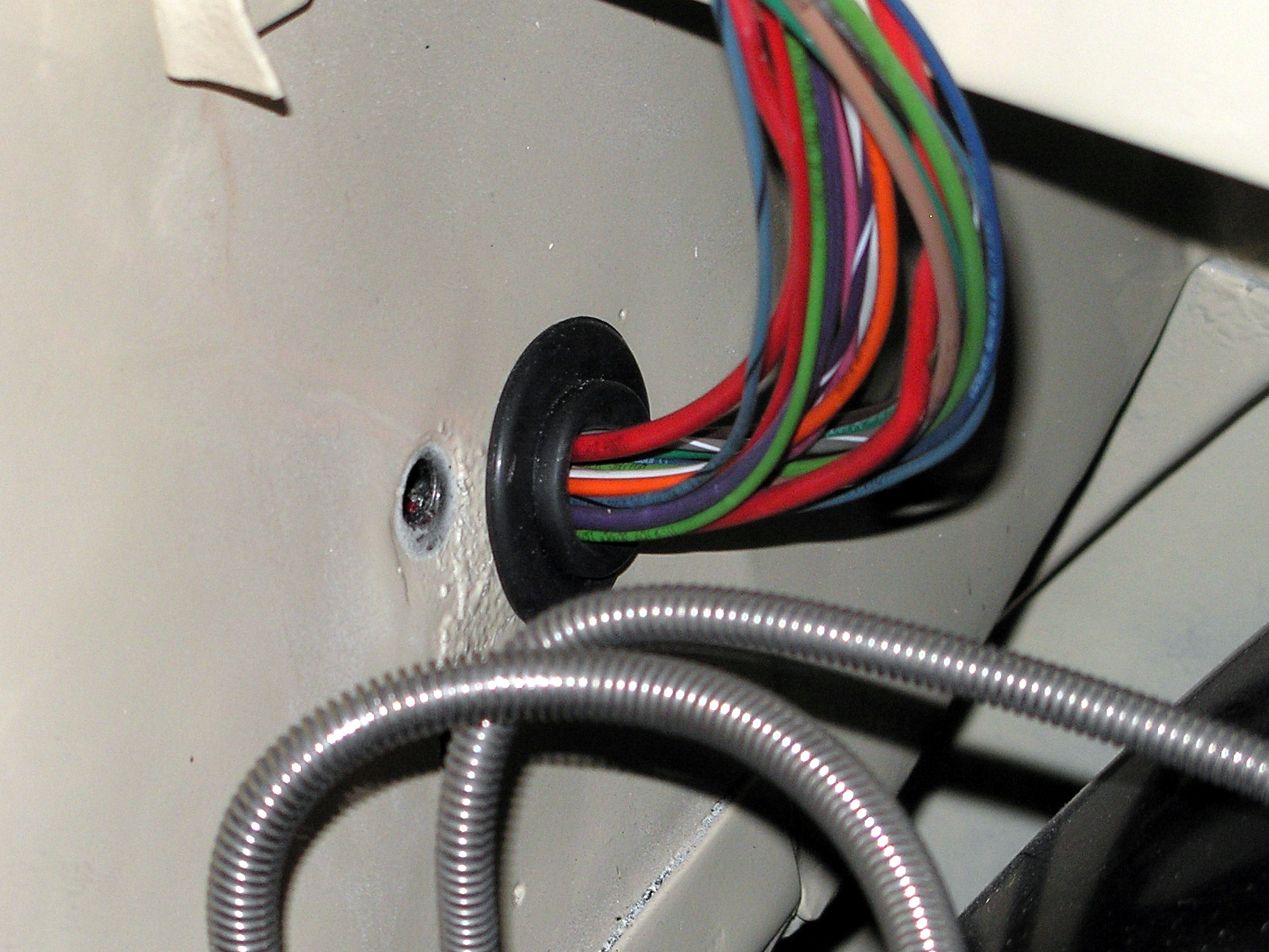 A complete automotive wiring harness laid out on cardboard, its taped branches ending in connectors