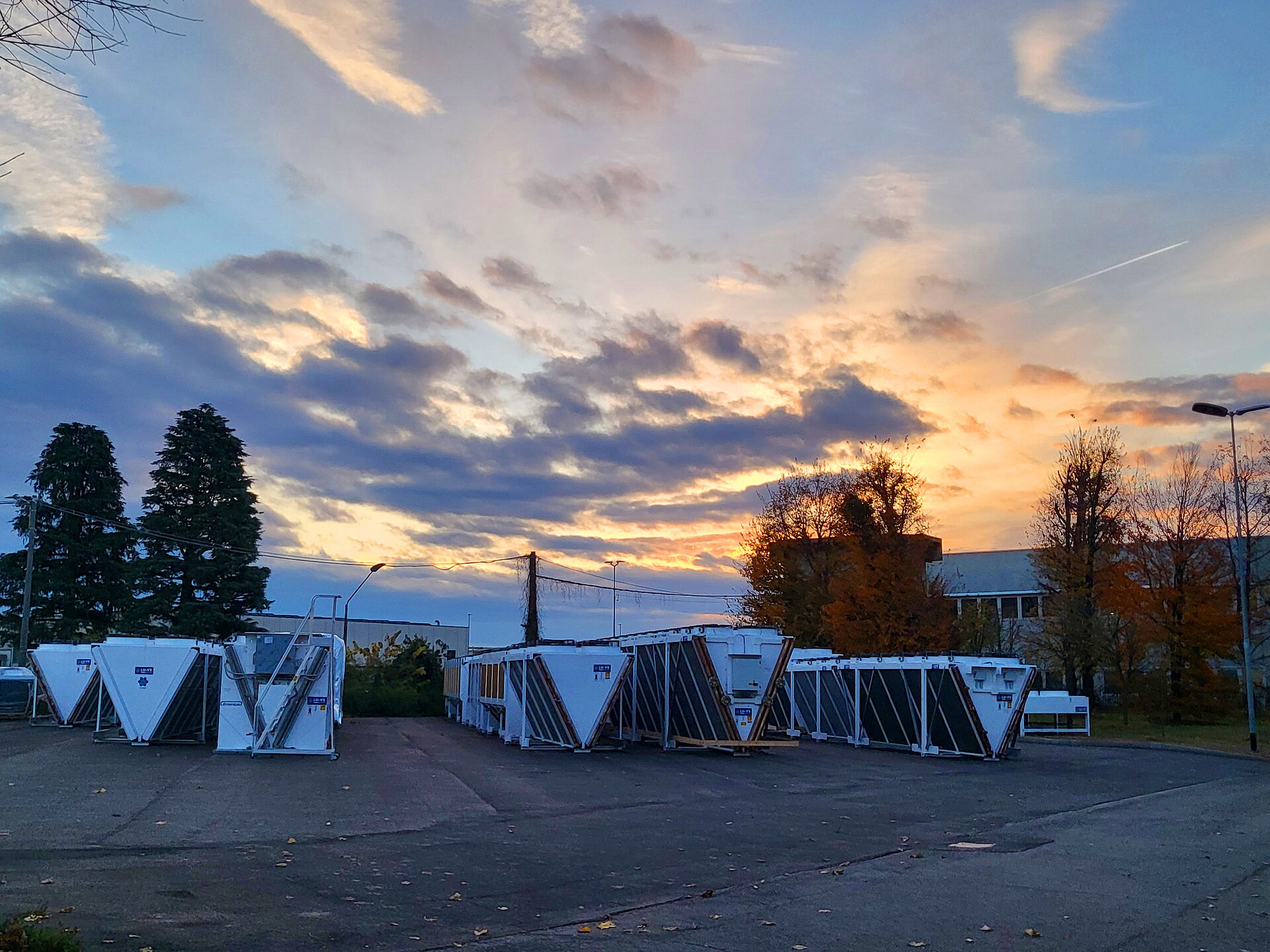 Rows of V-shaped dry coolers standing in a manufacturer's yard at sunset