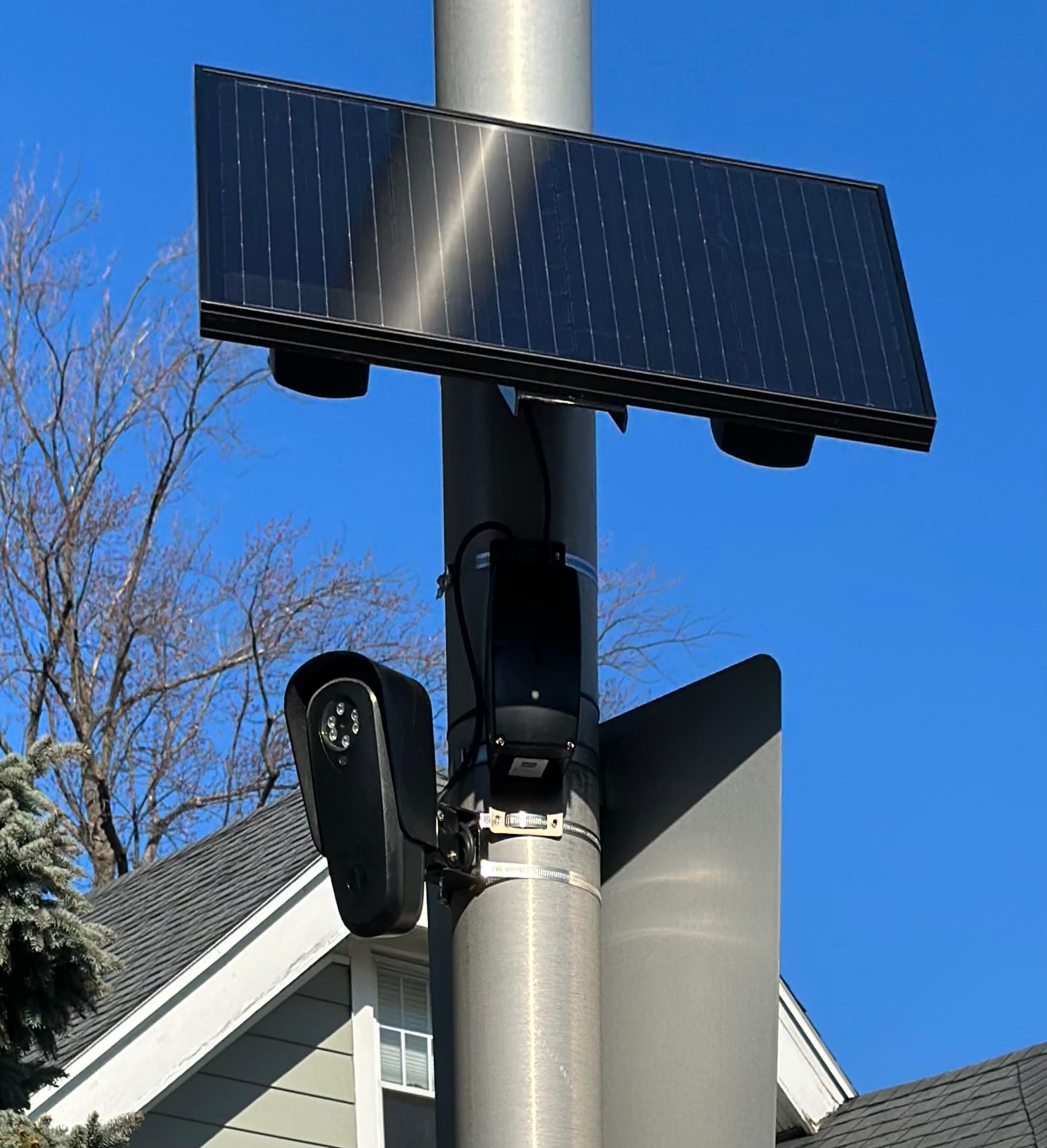 A Flock Safety automated license plate reader camera and its solar panel mounted on a street pole