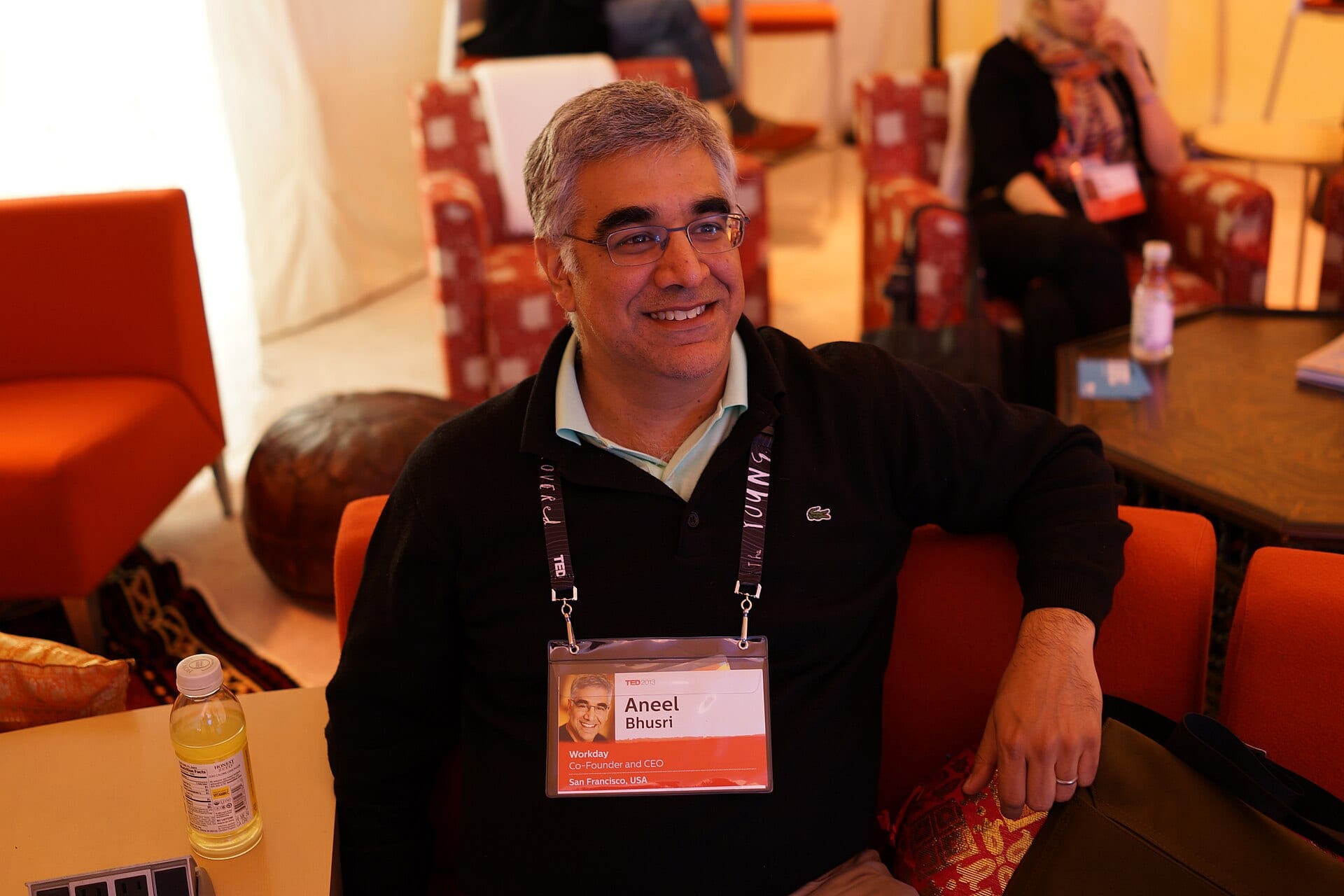 Workday chief executive Aneel Bhusri seated in a conference lounge, his badge reading Workday, Co-Founder and CEO